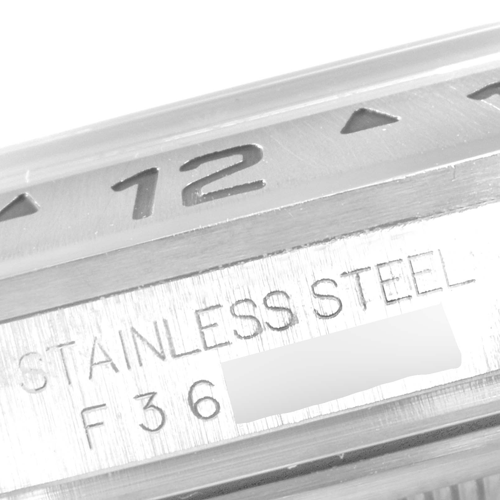 This close-up image of the Rolex Explorer 16570 Men
s Stainless Steel Black Dial 16570 Men
s Stainless Steel Black Dial watch shows part of the bezel, hour marker, and the "STAINLESS STEEL" engraving.