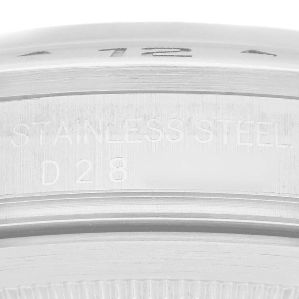 The image shows a close-up of the side of a Rolex Explorer 16570 Men
s Stainless Steel White Dial watch, focusing on the engraved “STAINLESS STEEL” marking.