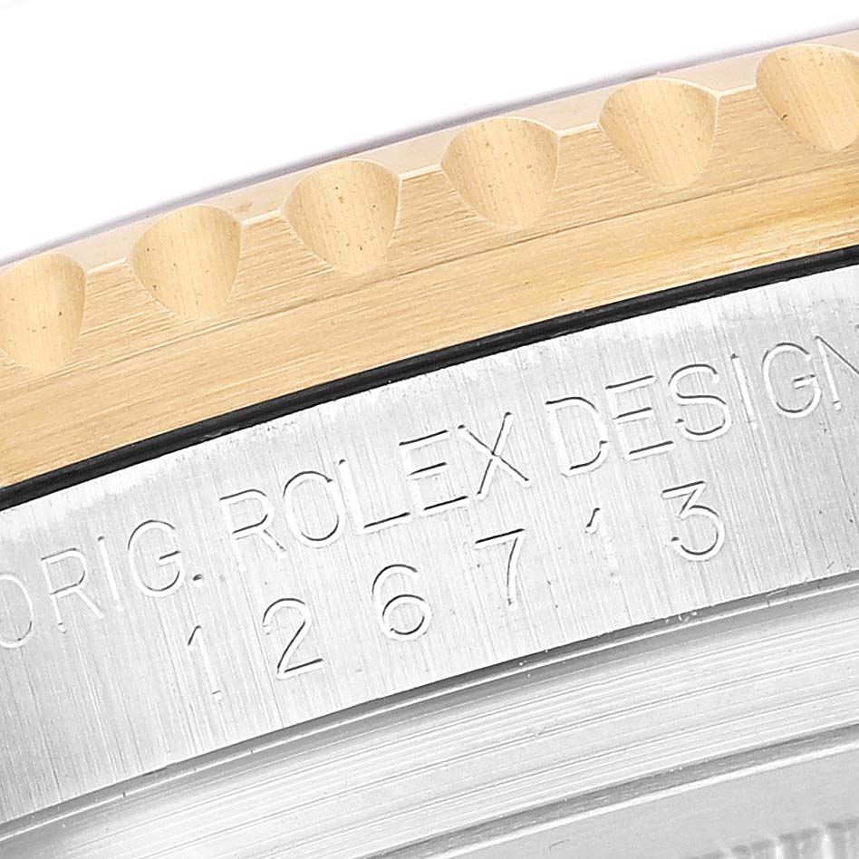 This image shows a close-up of the side of a Rolex GMT-Master 126713GRNR Men's Steel and Gold (two tone) Black Dial, highlighting the engraved model number and the edge of the bezel.