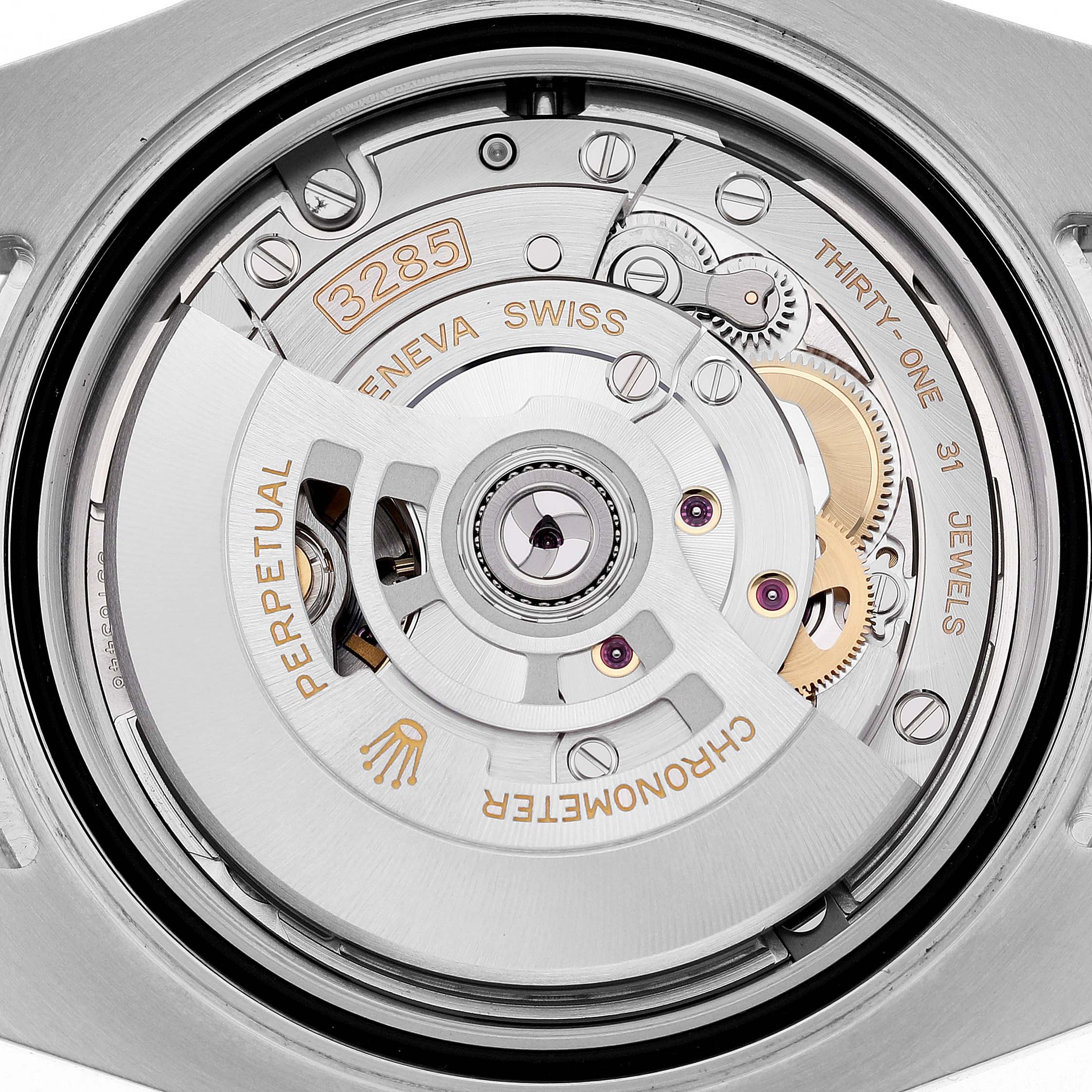 The image shows the movement of a Rolex GMT-Master 126713GRNR Men's Steel and Gold (two tone) Black Dial, focusing on the intricate internal components and engravings.