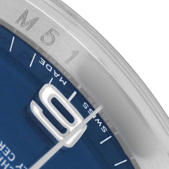 The image shows a close-up of the dial and bezel of a Rolex Oyster Perpetual 116034 Men's Stainless Steel Blue Dial watch, highlighting the "SWISS MADE" marking and hour marker.