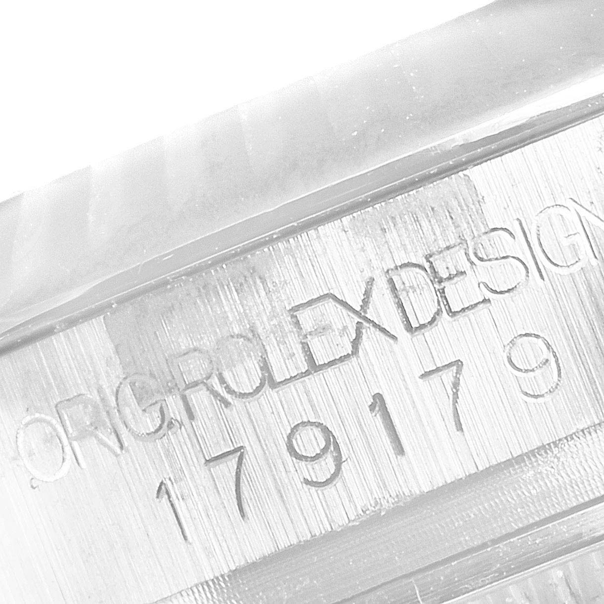 This image shows a close-up of the engraving on a Rolex President 179179 Women
s White Gold Silver Dial 179179 Women
s White Gold Silver Dial model watch, highlighting "OROLEX DESIGN" and the serial number "179179."