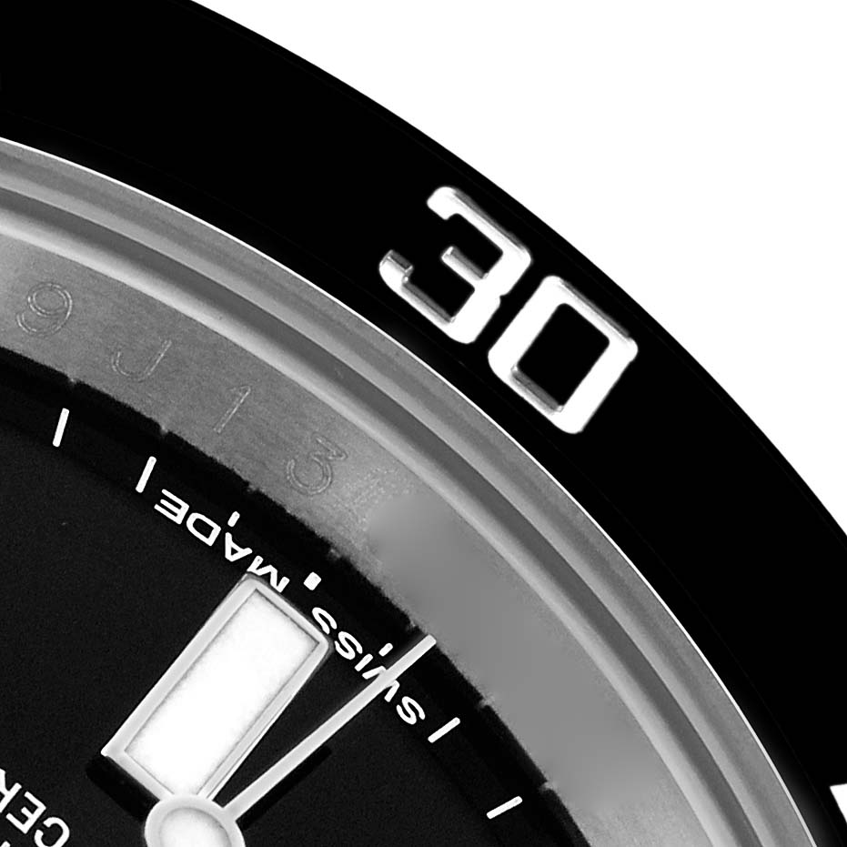 The image shows a close-up of the 30-minute marker on the bezel and part of the dial of a Rolex Submariner 116610 Men's Stainless Steel Black Dial watch.
