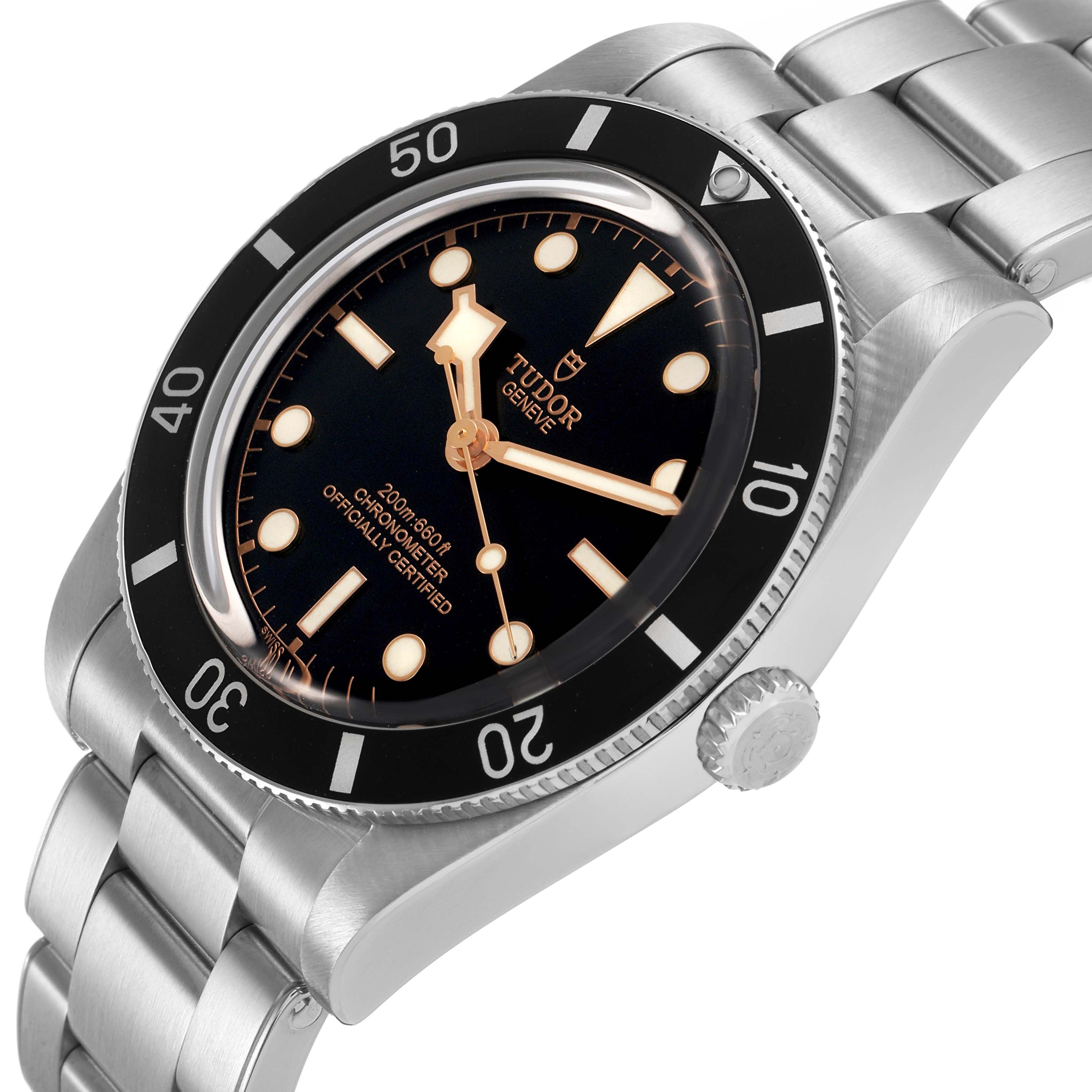 The Tudor Heritage Black Bay M79000N-0002 Men's Stainless Steel Black Dial watch is shown from a tilted angle, highlighting the dial, bezel, crown, and bracelet.