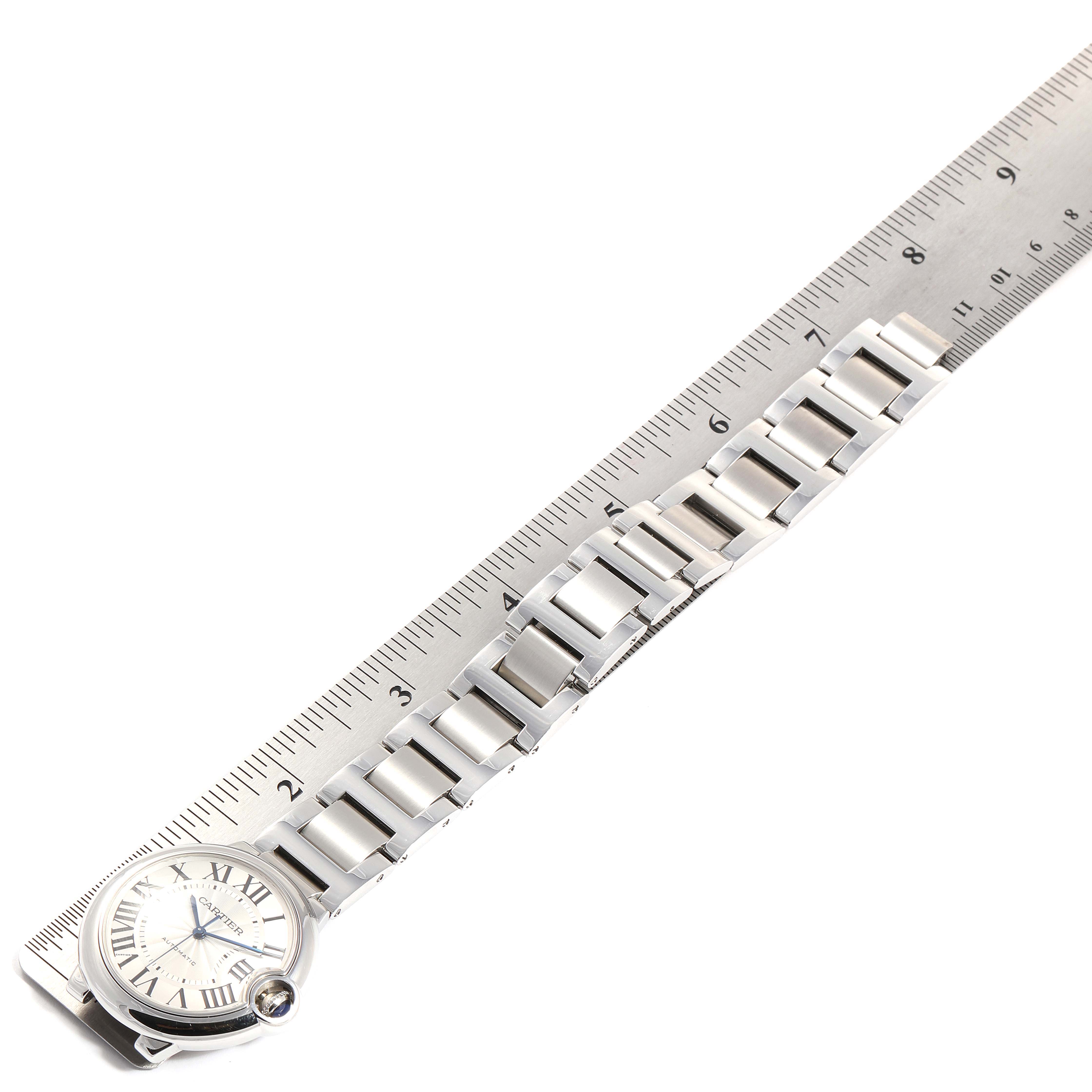 The image shows the face and bracelet of a Ballon Bleu Cartier watch next to a ruler.