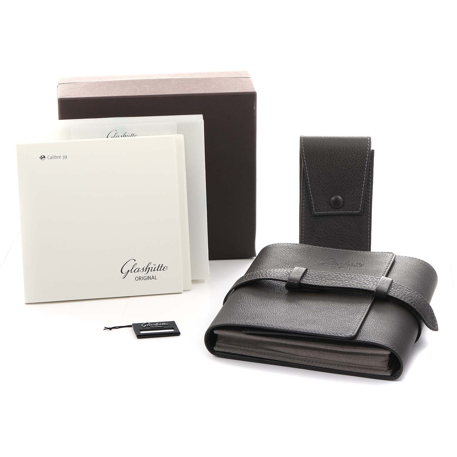 The image shows the packaging and accessories of the Glashütte Original watch, including a leather pouch, box, and booklets.
