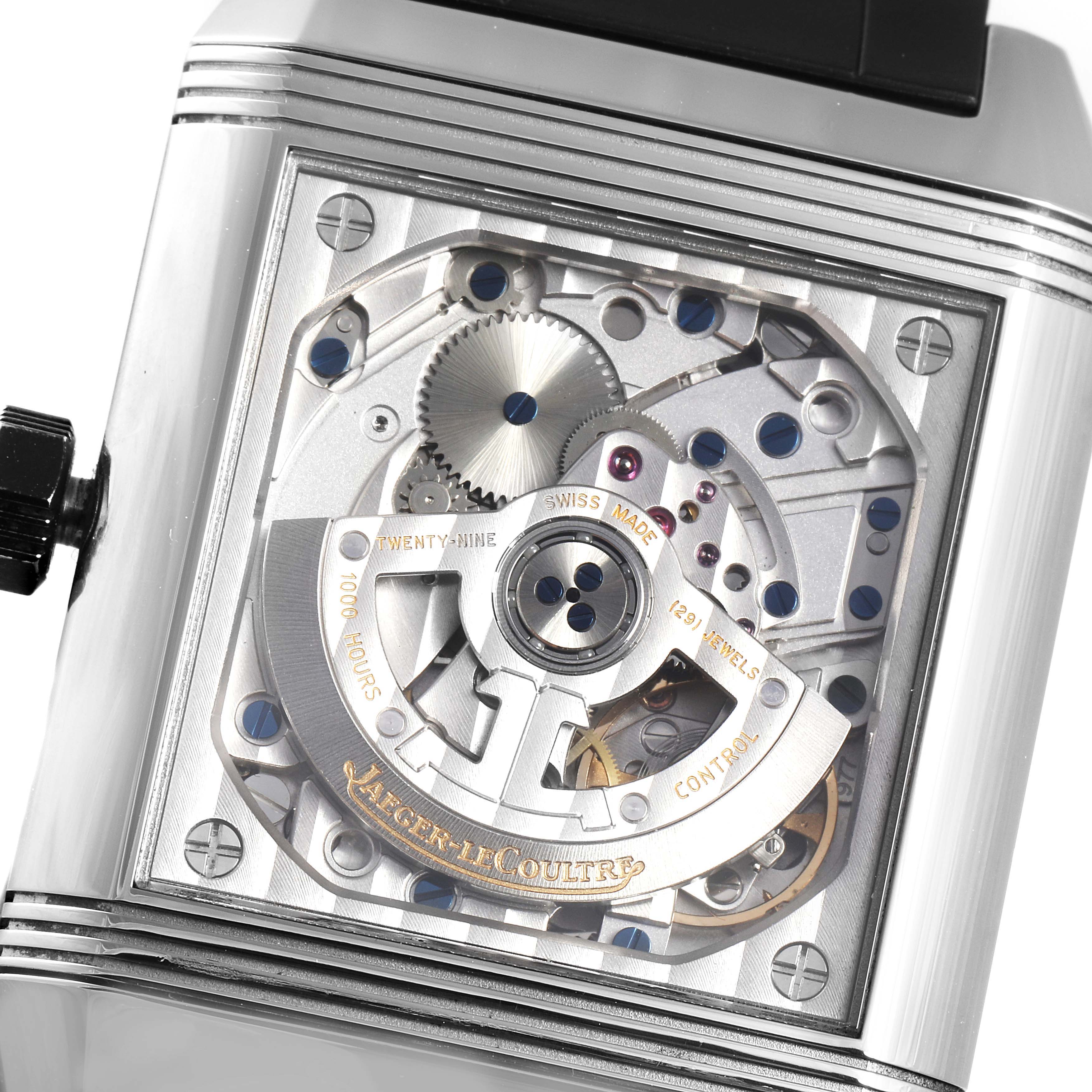The image shows the inner mechanism of a Jaeger-LeCoultre Reverso watch, focusing on its intricate gears and components.
