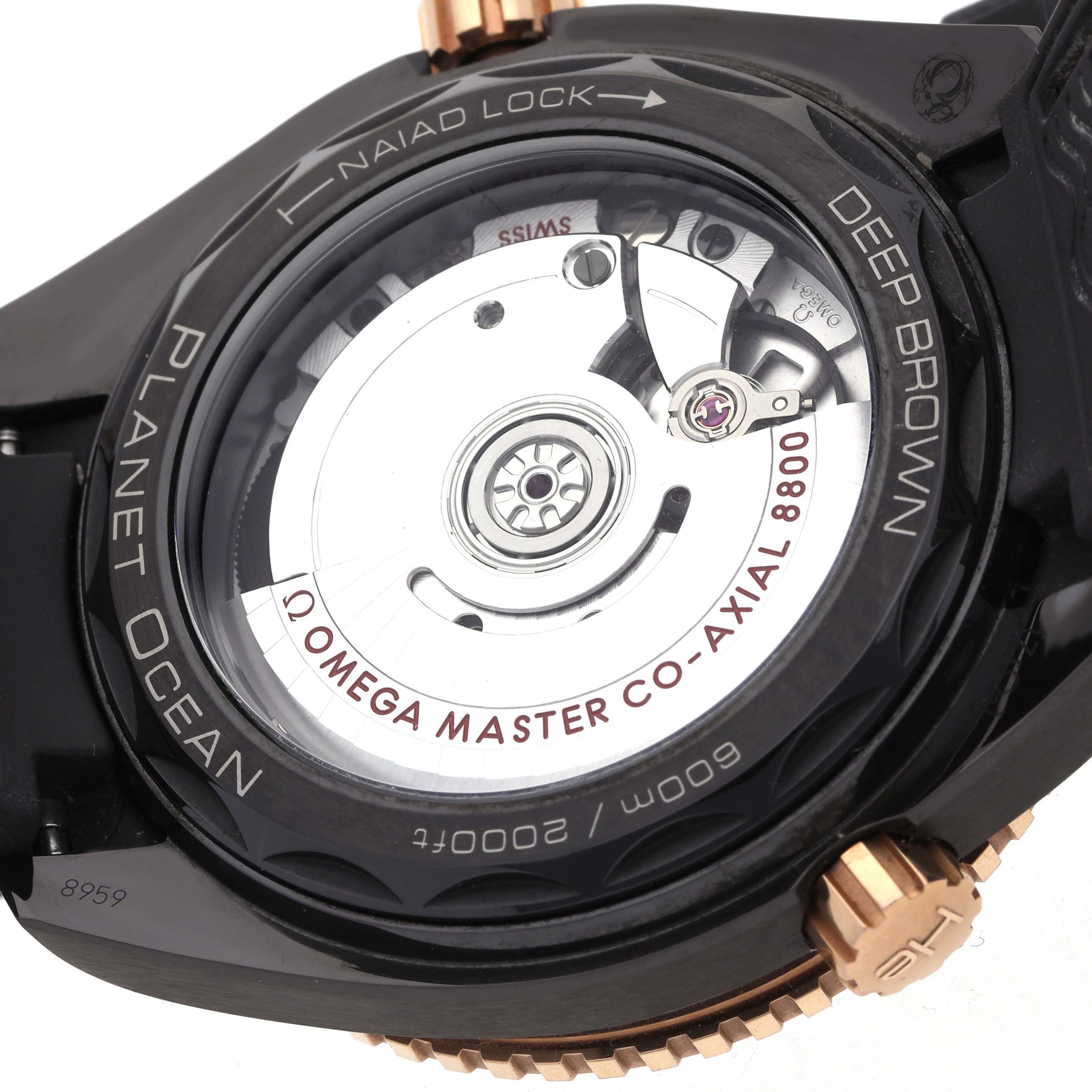 The image shows the back view of the Omega Planet Ocean 215.62.40.20.13.001 Men
s Rose Gold Black Dial, highlighting its movement and rotor.