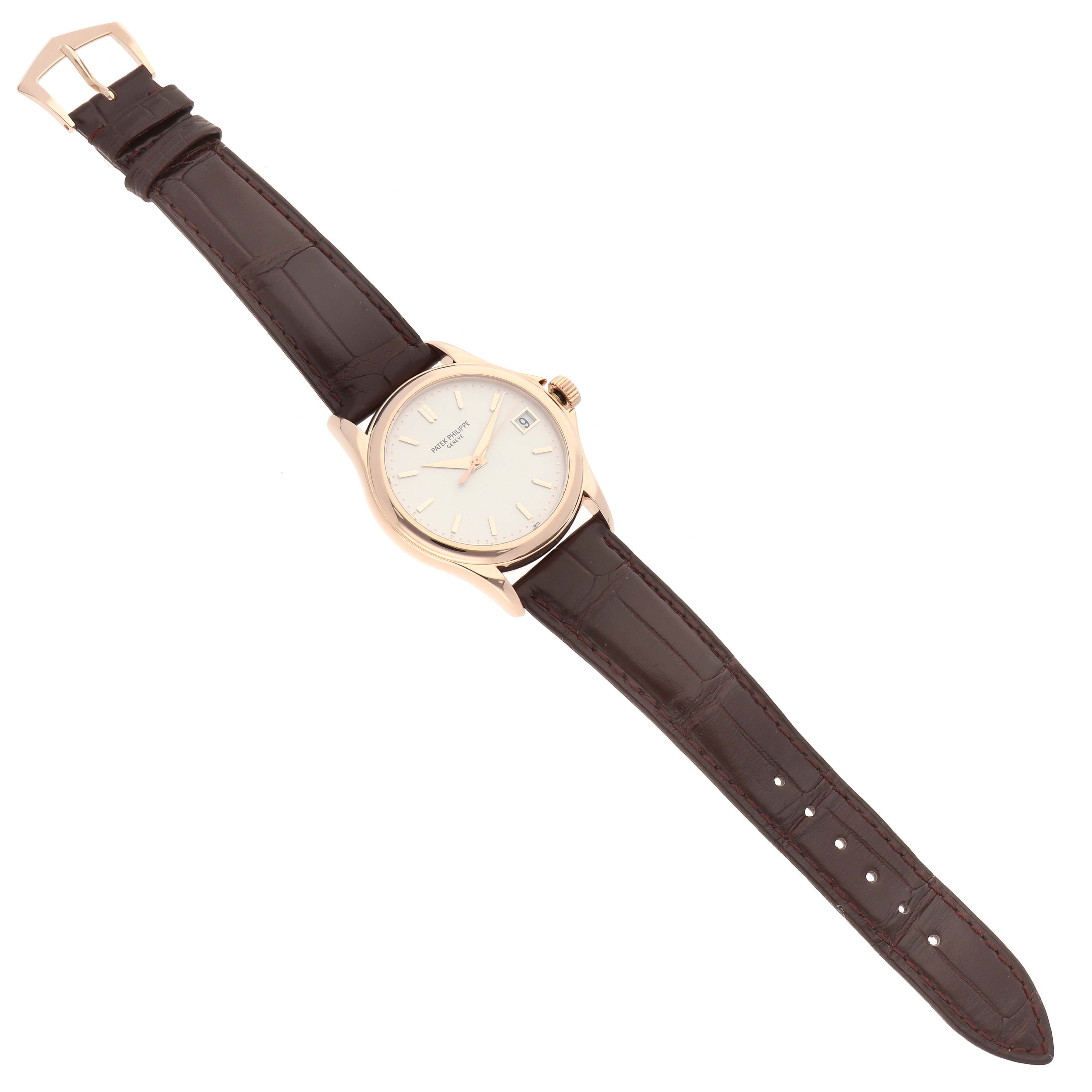 The Patek Philippe Calatrava 5127R-001 Men's Rose Gold Silver Dial 5127R-001 Men's Rose Gold Silver Dial watch is shown from a top-down angle, featuring its dial, case, crown, and brown leather strap.