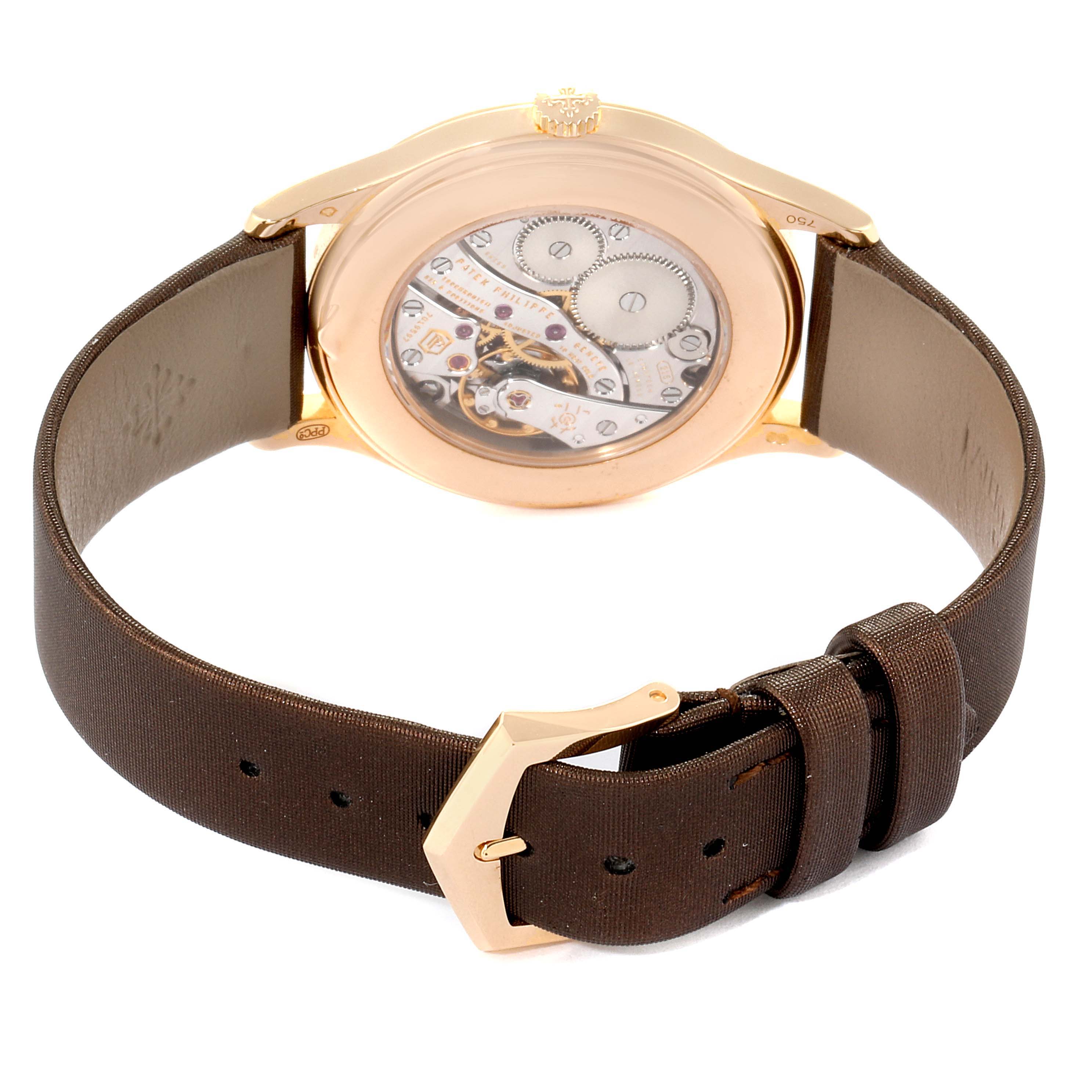 The image shows the back view of the Patek Philippe Calatrava 4897R-001 Women's Rose Gold Brown Dial 4897R-001 Women's Rose Gold Brown Dial watch, highlighting the mechanical movement and brown leather strap.