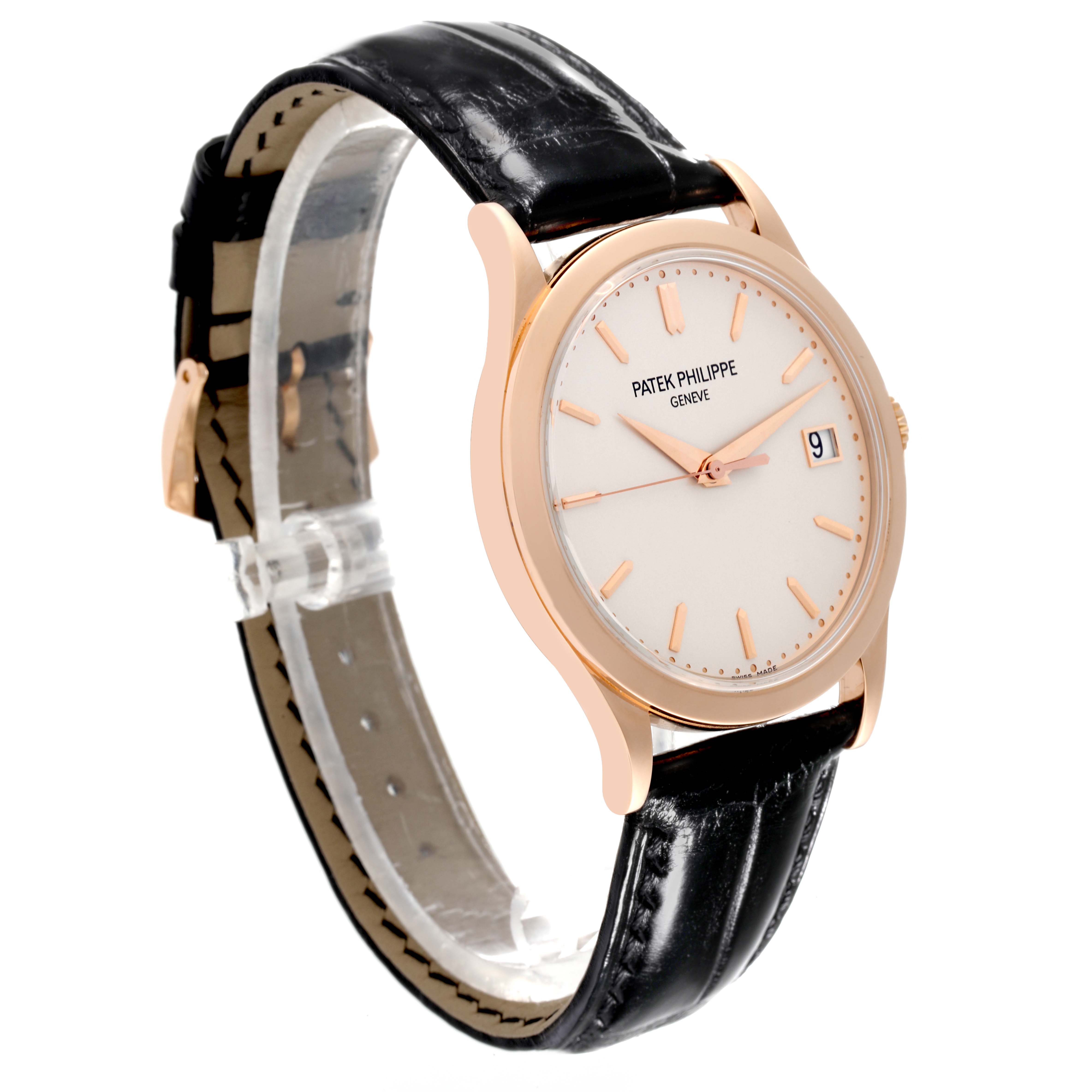 The Calatrava model by Patek Philippe is shown at a three-quarter angle, displaying the face, hands, date window, and leather strap.