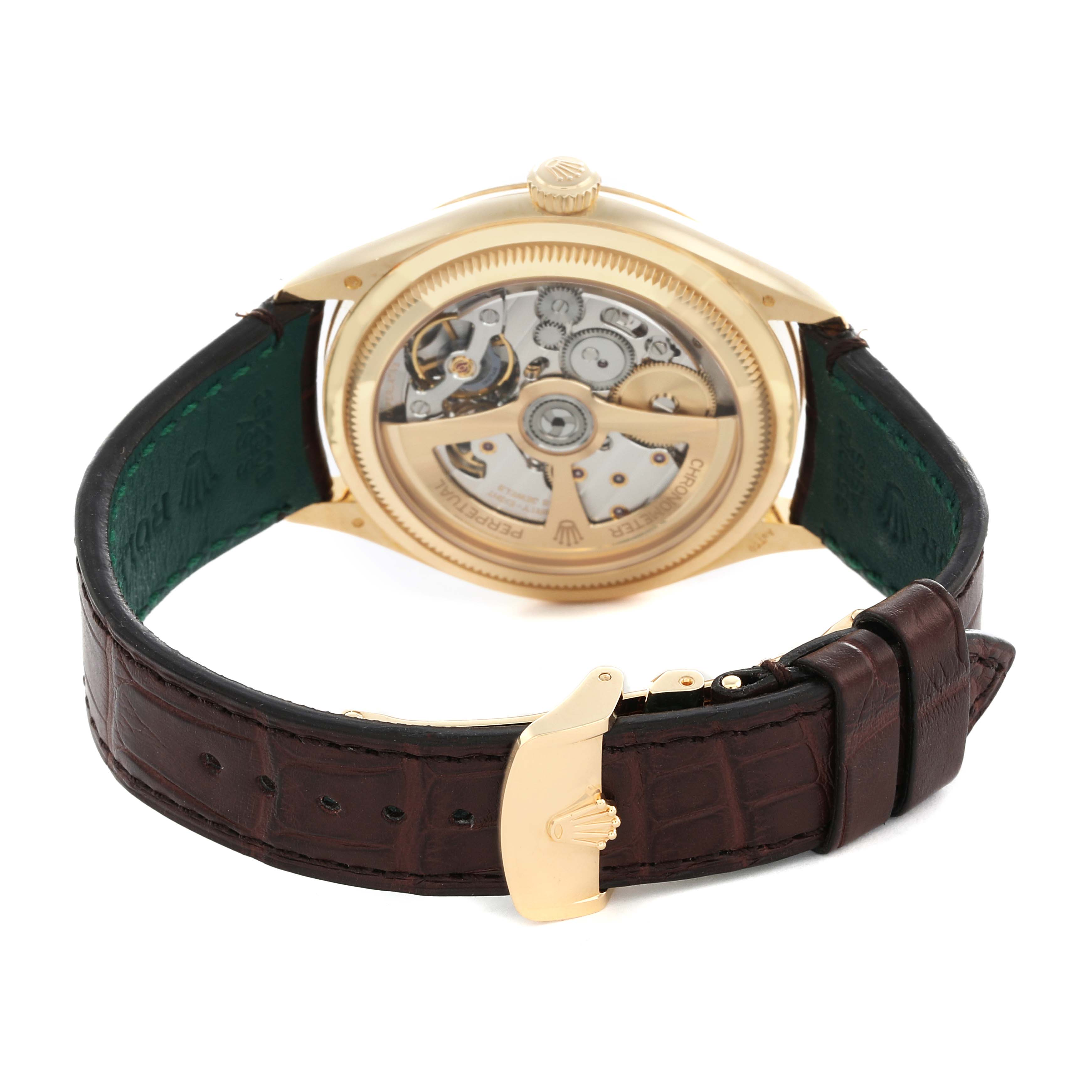 The Rolex 1908 52508-0006 Men
s Yellow Gold White Dial watch is shown from the back, highlighting its open case back and movement, with a brown leather strap and gold clasp.