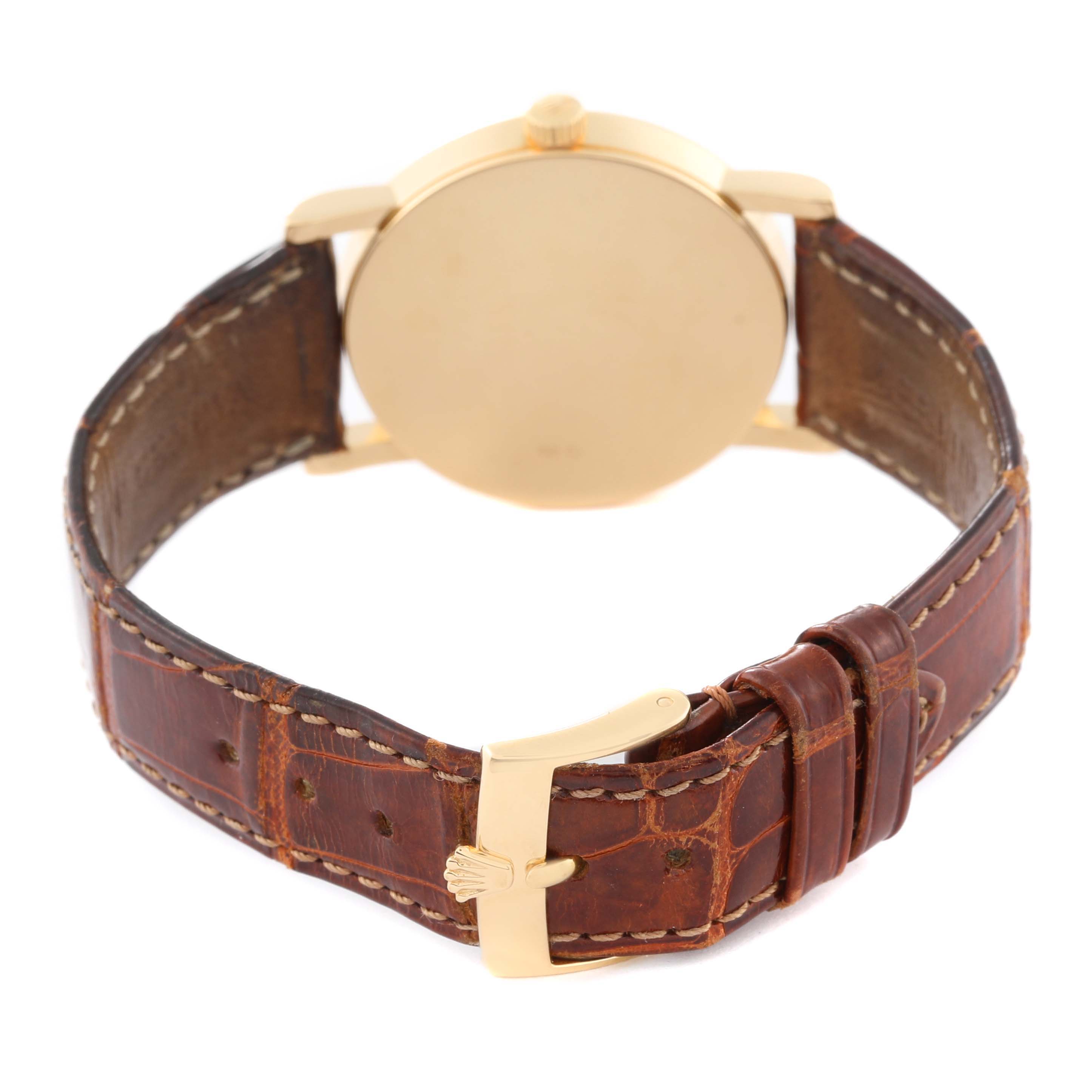 The Rolex Cellini 5115 Men's Yellow Gold Silver Dial 5115 Men's Yellow Gold Silver Dial watch is shown from the back, displaying its case, gold buckle, and brown leather strap.