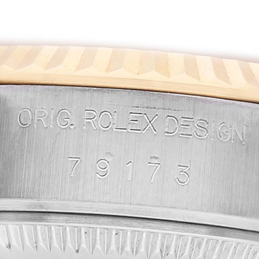 The image shows a close-up of the Rolex Datejust 79173 Women's Stainless Steel Champagne Dial's side, highlighting the engraved design and model number near the bezel.