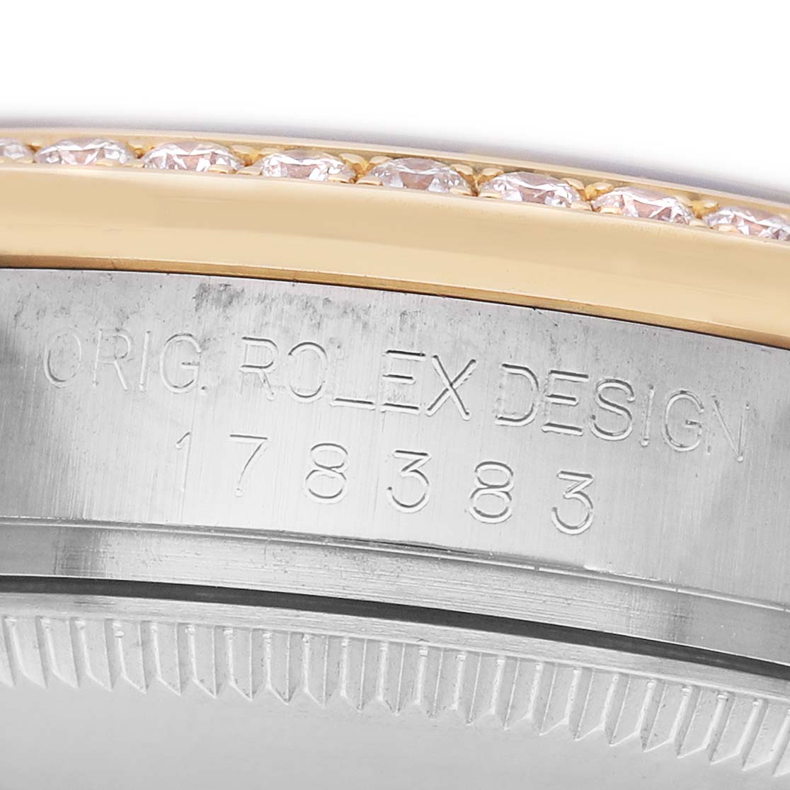The image shows a close-up of the Rolex Datejust 178383 Women's Steel and Gold (two tone) Black Dial model's side, featuring the engraved model and design details, with a diamond-set bezel.