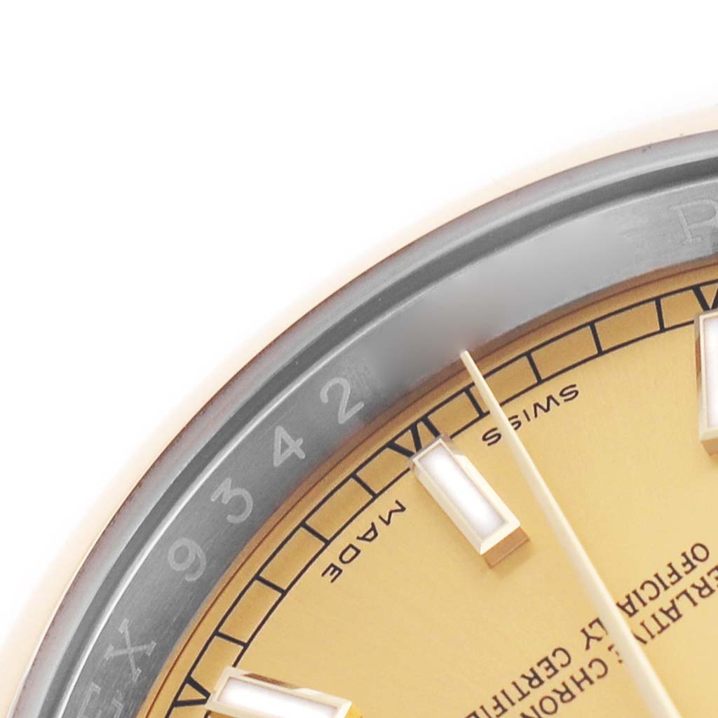 The image shows a close-up of the bezel and part of the dial of a Rolex Datejust 116203 Men's Stainless Steel Champagne Dial watch at an angle.