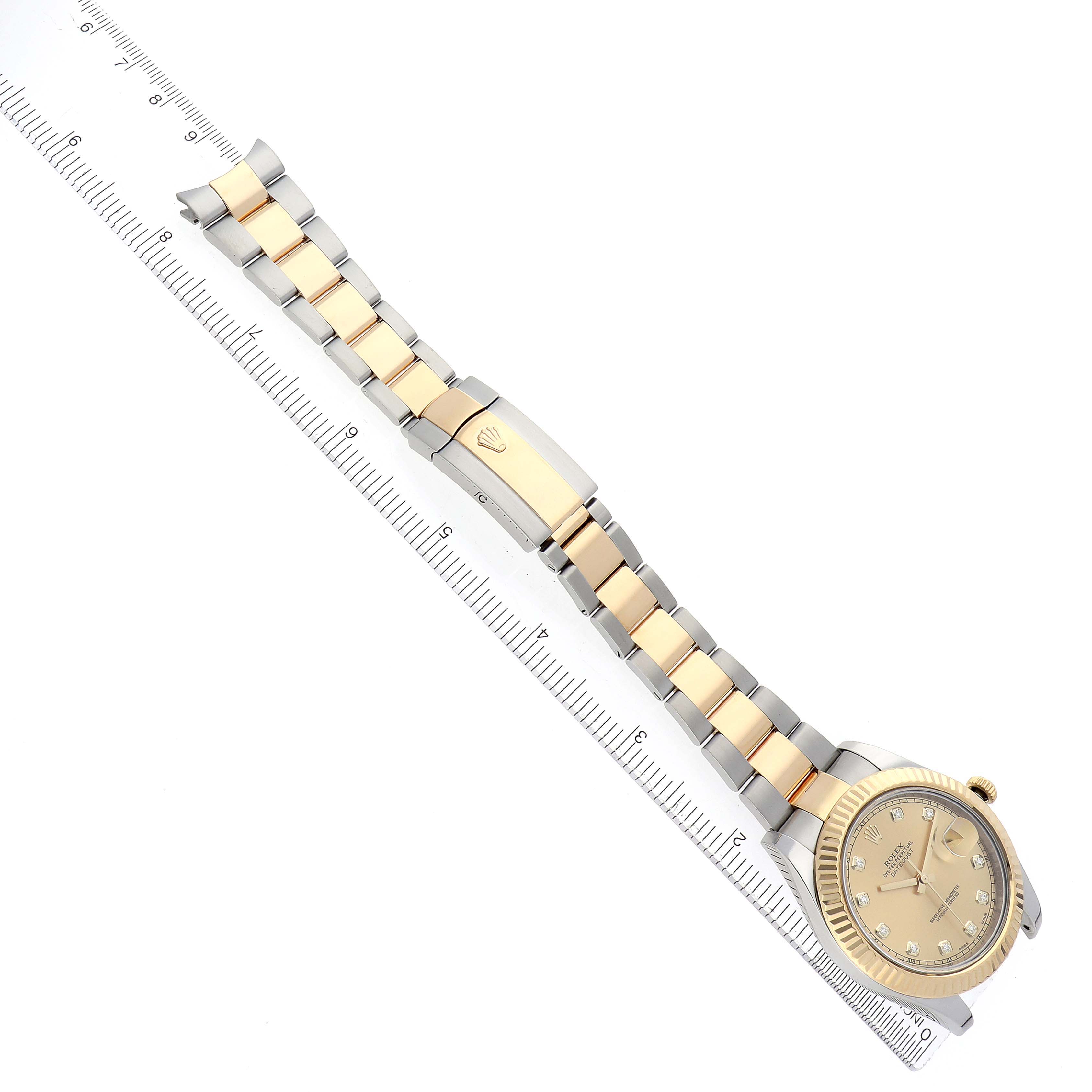 The Rolex Datejust 116333 Men
s Steel and Gold (two tone) Champagne Dial watch is shown at a slight diagonal angle, featuring its face, bezel, and two-tone bracelet on a ruler background.