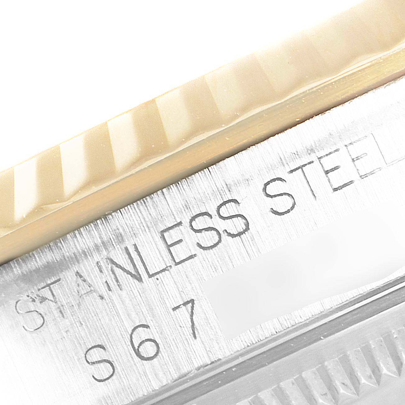 This close-up image shows the engraving on the stainless steel case and the edge of the fluted bezel of a Rolex Datejust 16233 Men
s Steel and Gold (two tone) Champagne Dial 16233 Men
s Steel and Gold (two tone) Champagne Dial watch.