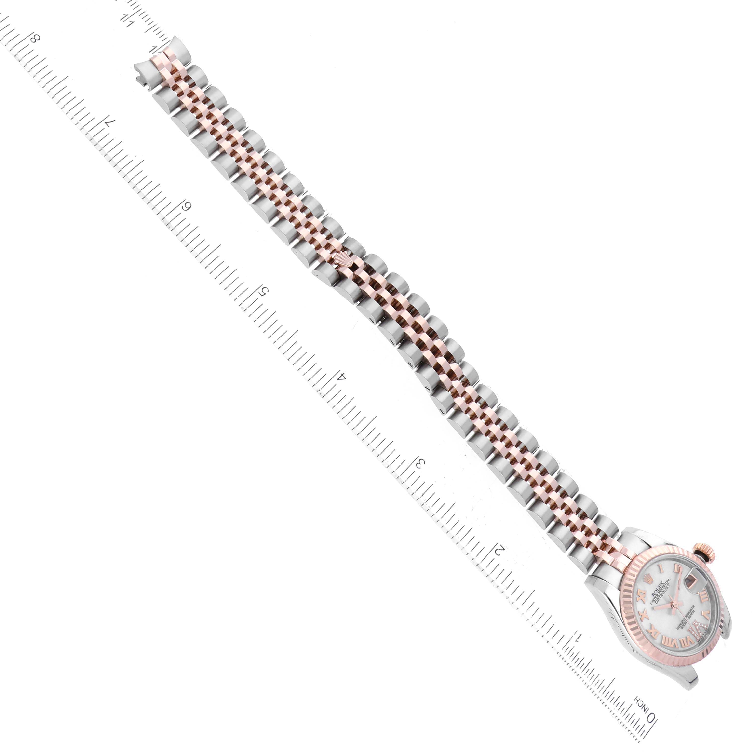 The image shows the Rolex Datejust 179171 Women's Steel and Gold (two tone) Mother of Pearl Dial 179171 Women's Steel and Gold (two tone) Mother of Pearl Dial watch laying flat at an angle, with focus on the face and bracelet alongside a ruler for scale.
