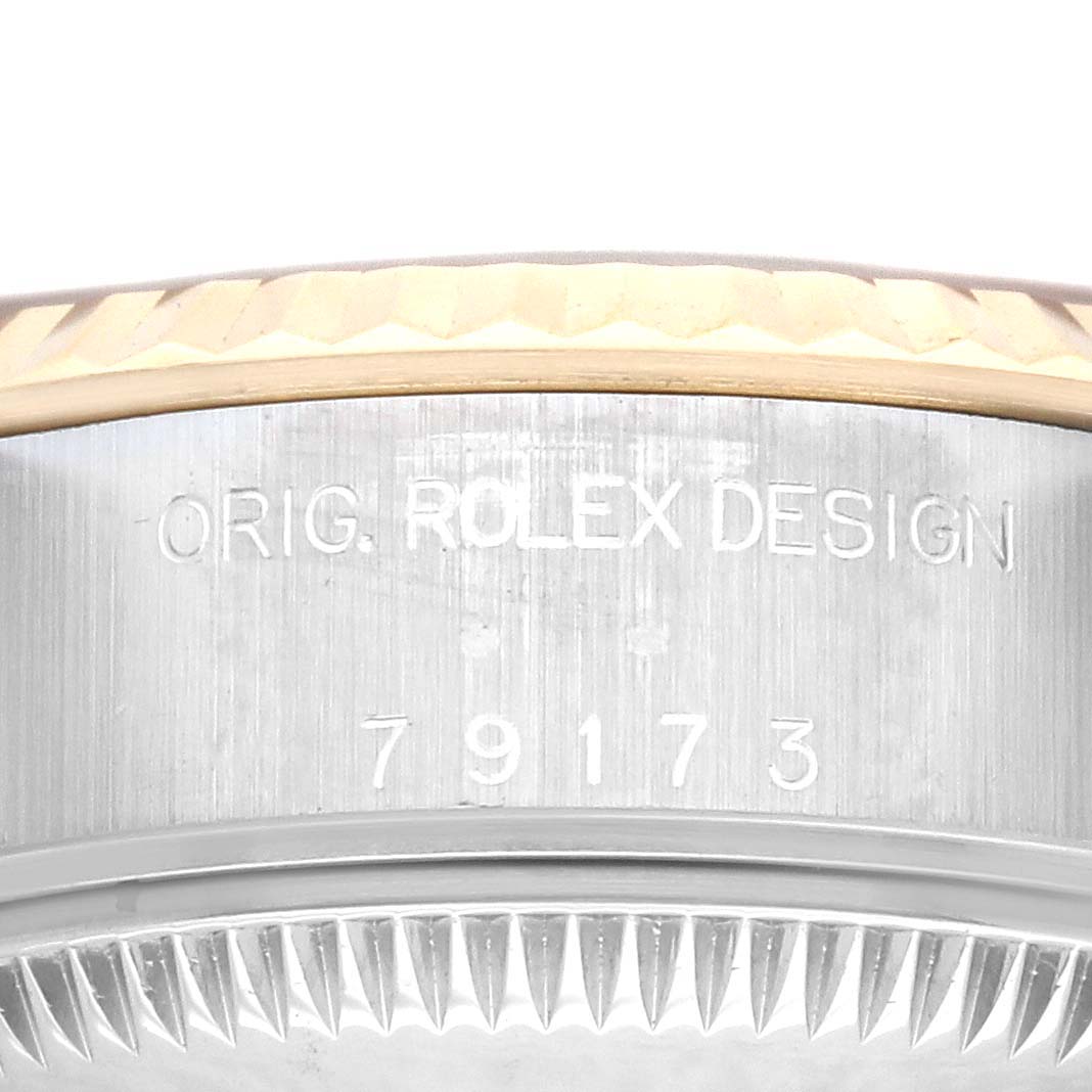 This image shows a close-up view of the side of the Rolex Datejust 79173 Women's Steel and Gold (two tone) Champagne Dial 79173 Women's Steel and Gold (two tone) Champagne Dial, featuring the model number and "ORIG. ROLEX DESIGN" engraving.