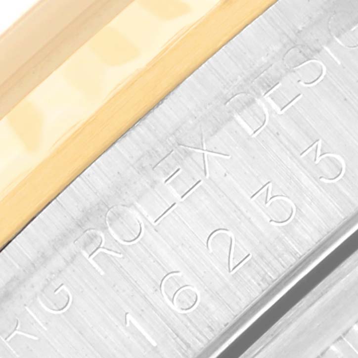 This close-up shot of a Rolex Datejust 16233 Men's Steel and Gold (two tone) Champagne Dial 16233 Men's Steel and Gold (two tone) Champagne Dial shows the side engraving detailing and part of the bezel.