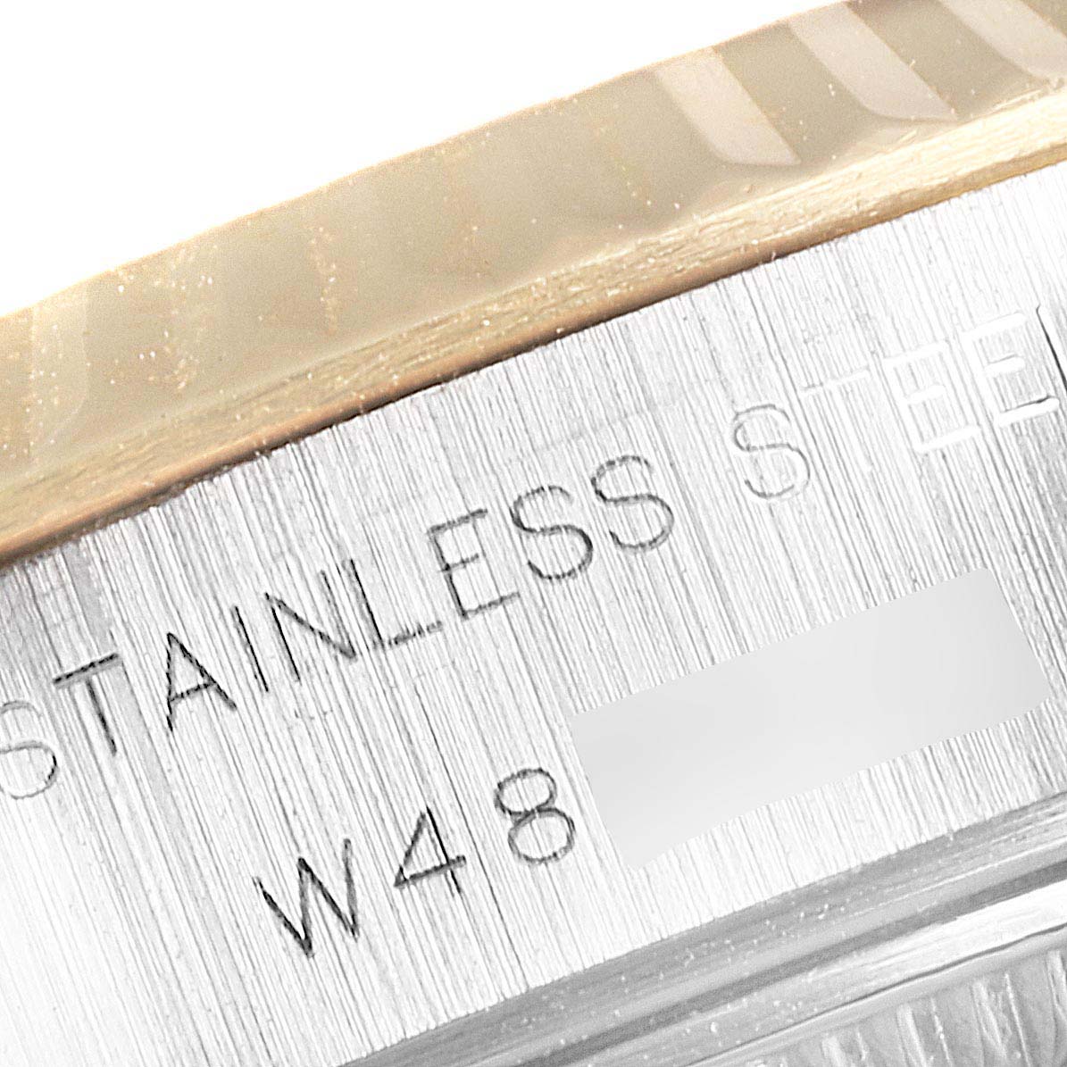 This close-up image of a Rolex Datejust 69173 Women
s Steel and Gold (two tone) Champagne Dial 69173 Women
s Steel and Gold (two tone) Champagne Dial watch shows part of the bezel and "STAINLESS STEEL" engraving.
