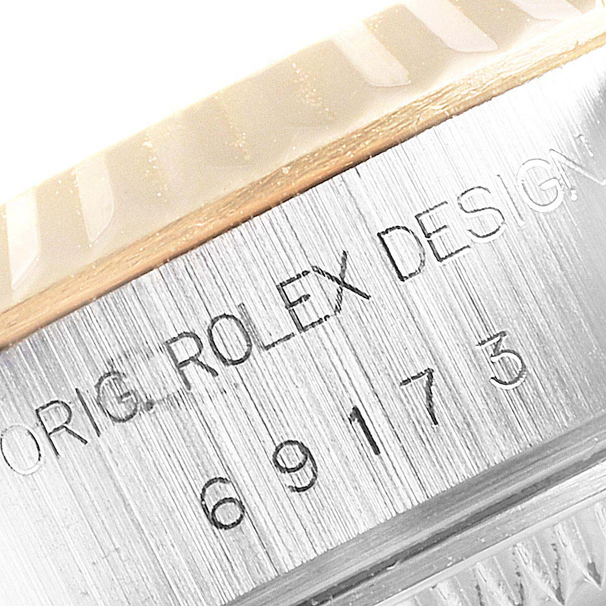 This image shows a close-up of the Rolex Datejust 69173 Women
s Steel and Gold (two tone) Champagne Dial 69173 Women
s Steel and Gold (two tone) Champagne Dial watch casing, displaying the "ROLEX DESIGN" engraving and model number.