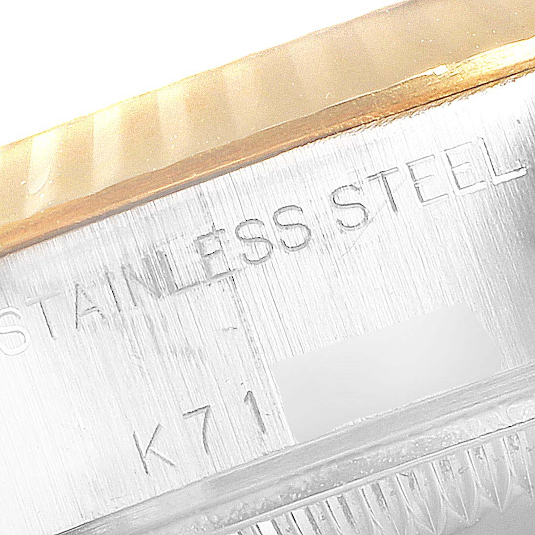This close-up image shows the engraved stainless steel part of a Rolex Datejust 79173 Women's Steel and Gold (two tone) Champagne Dial 79173 Women's Steel and Gold (two tone) Champagne Dial watch case.