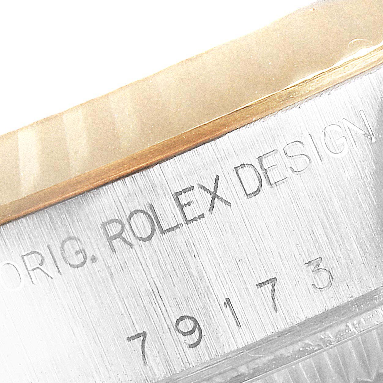 The image shows a close-up of the engraving on the side of a Rolex Datejust 79173 Women's Steel and Gold (two tone) Champagne Dial 79173 Women's Steel and Gold (two tone) Champagne Dial watch.