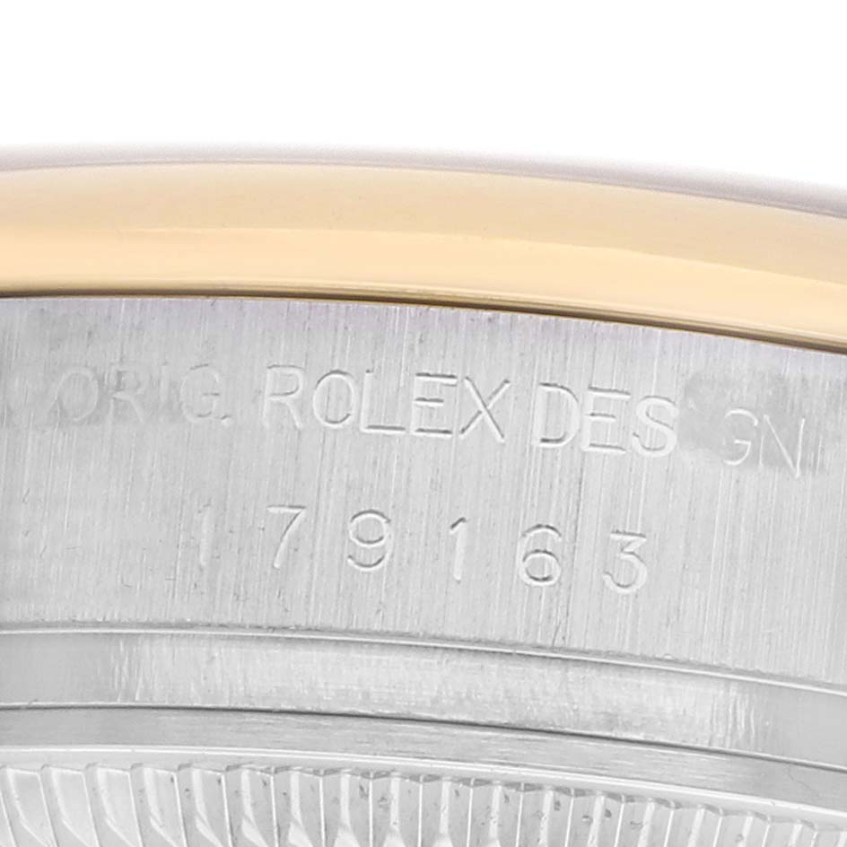 The image shows a close-up of the Rolex Datejust 179163 Women
s Steel and Gold (two tone) Silver Dial watch case, highlighting the engraved numbers and edge of the bezel.