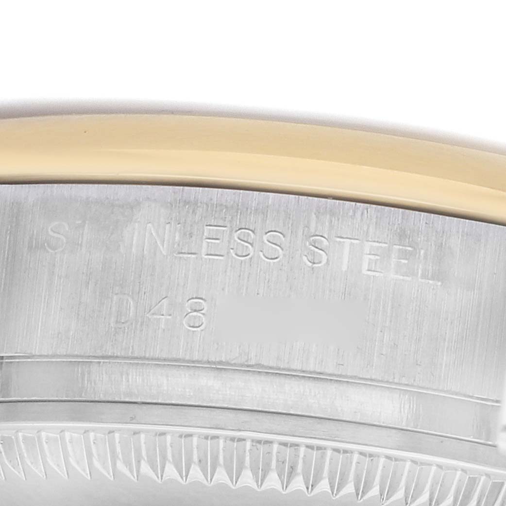 The image shows the side of a Rolex Datejust 179163 Women
s Steel and Gold (two tone) Silver Dial watch, highlighting the stainless steel case with engravings and a partial view of the gold bezel.