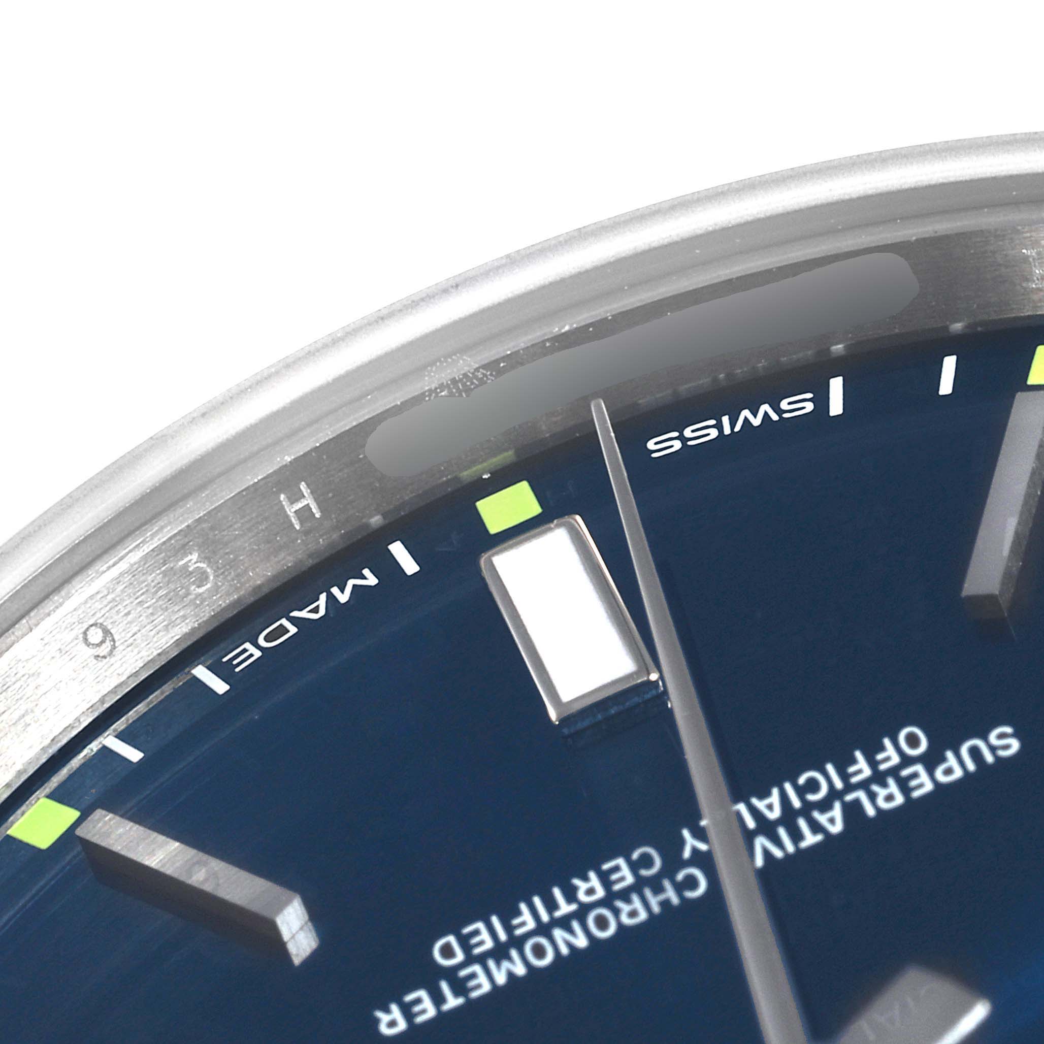 The image shows a close-up of the dial, hands, and markers of the Rolex Oyster Perpetual 114300 Men's Stainless Steel Blue Dial 114300 Men's Stainless Steel Blue Dial watch.