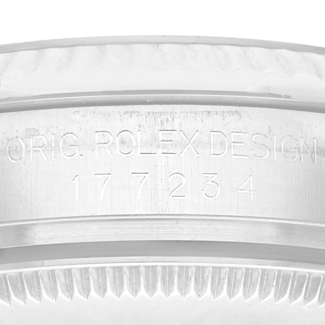 The image shows the side of a Mid-Size Rolex watch case, detailing engraved text and the ridged edge of the bezel.