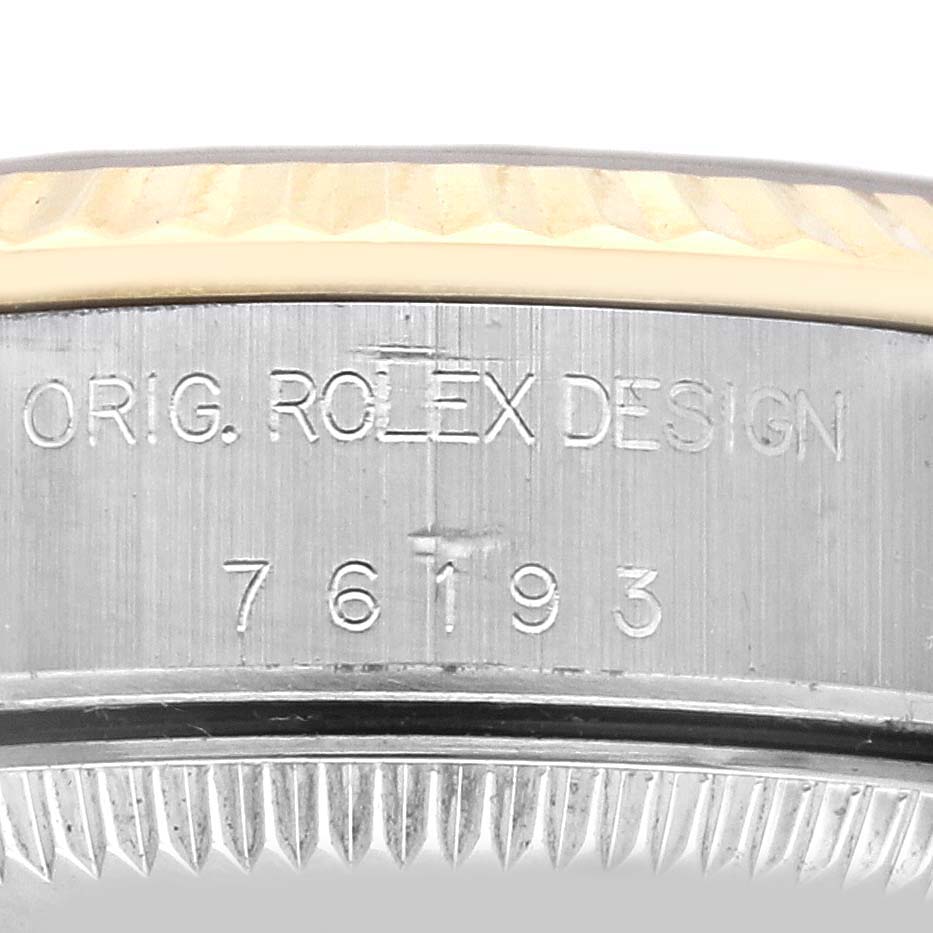 This close-up angle shows the side engraving and partial bezel of a Rolex Oyster Perpetual 76193 Women's Steel and Gold (two tone) Champagne Dial 76193 Women's Steel and Gold (two tone) Champagne Dial watch.