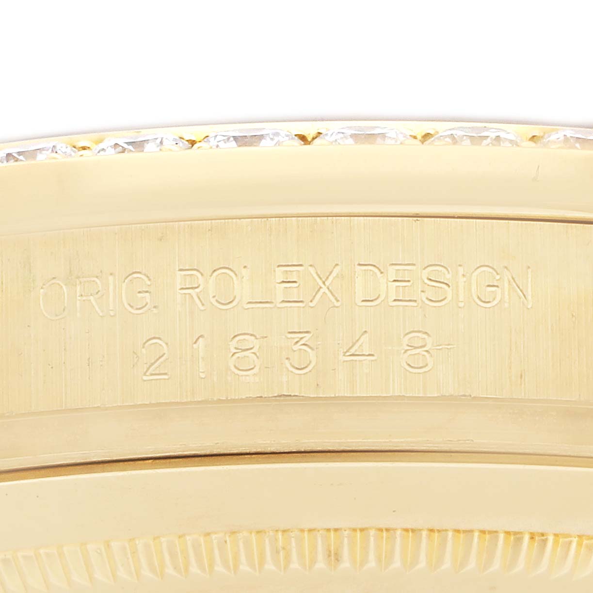 The image shows a close-up of the side of a Rolex President 218348 Men
s Yellow Gold Champagne Dial model, highlighting the engraved design number.