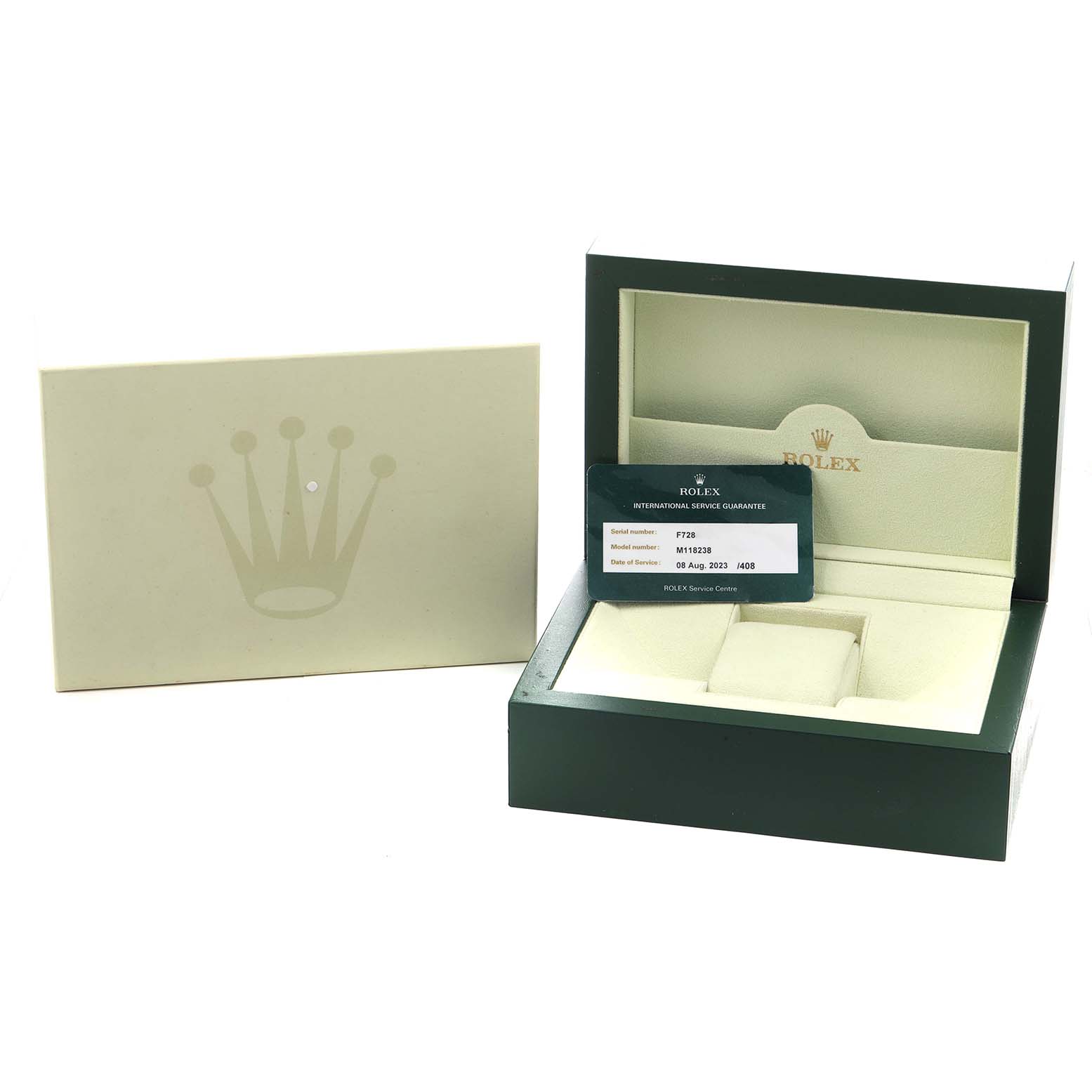 The image shows the Rolex President 118238 Men
s Yellow Gold Champagne Dial model watch box at a slight angle with the warranty card, inside the green box.