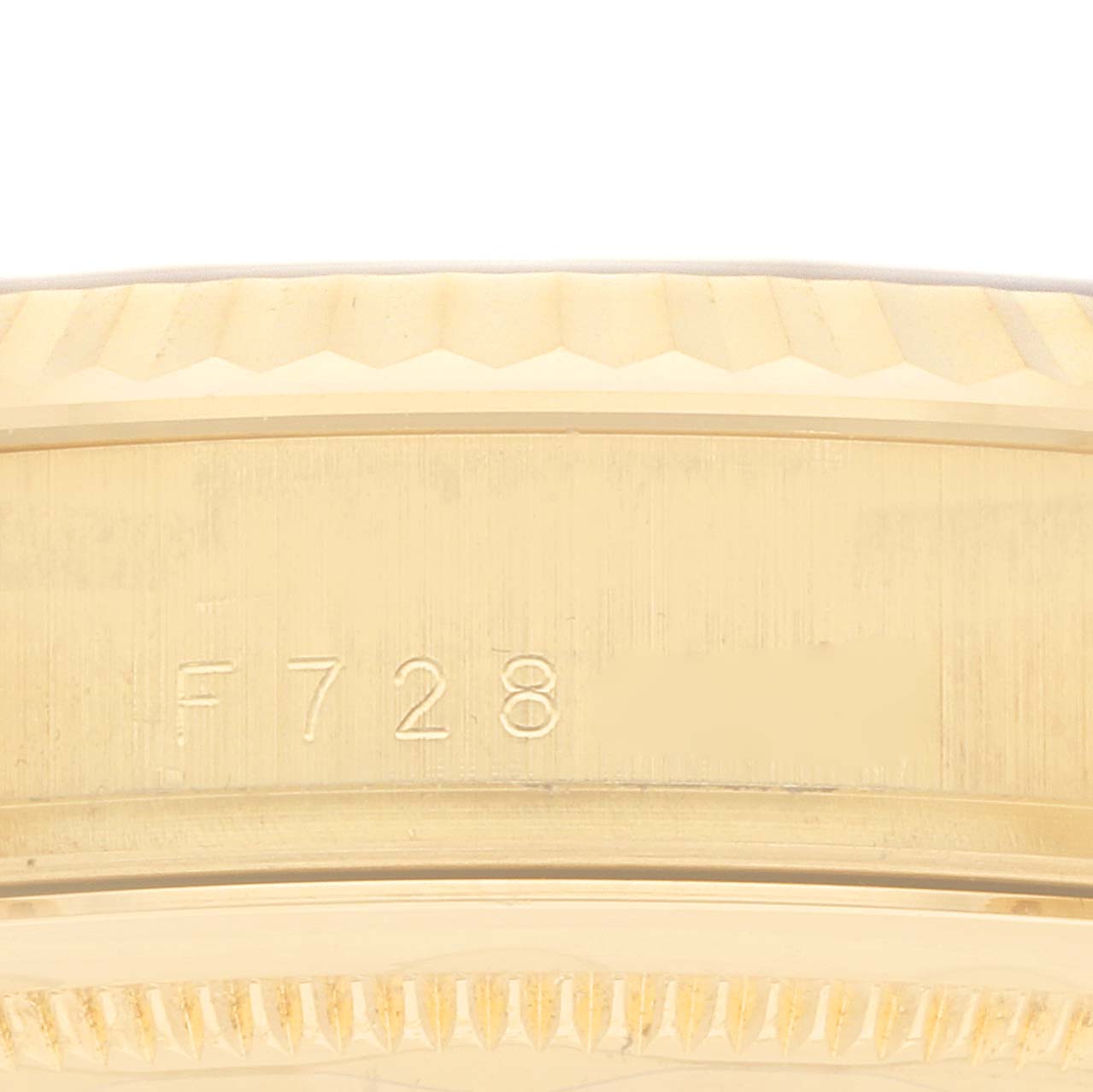The image shows the edge and part number engraving on the side of the Rolex President 118238 Men
s Yellow Gold Champagne Dial watch bezel.