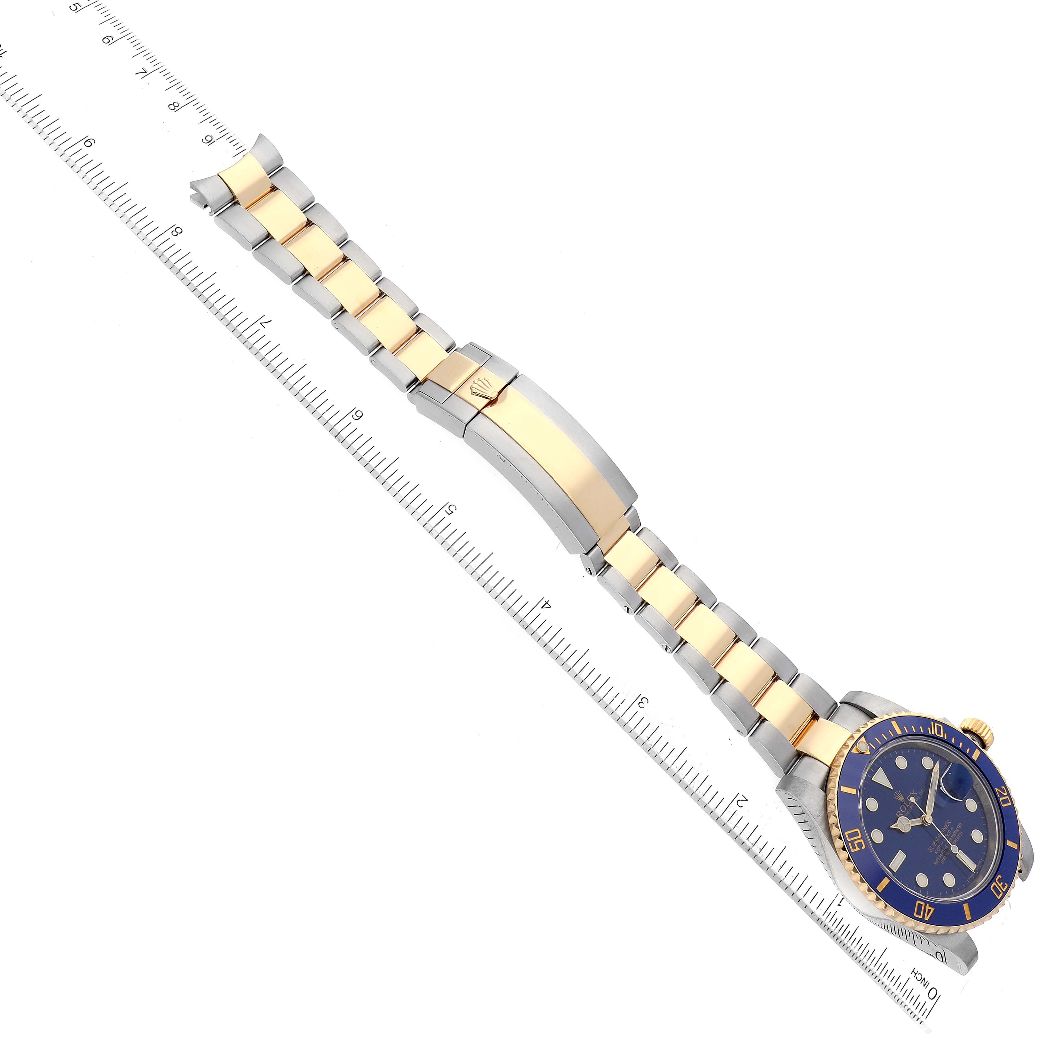 The image shows a side angle of a Rolex Submariner 116613 Men's Steel and Gold (two tone) Blue Dial 116613 Men's Steel and Gold (two tone) Blue Dial watch, focusing on its bracelet, clasp, and partial view of the blue dial and bezel.