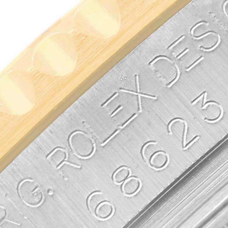 This close-up image of a Rolex Yacht-Master 68623 Men's Steel and Gold (two tone) White Dial 68623 Men's Steel and Gold (two tone) White Dial shows part of the bezel and engraved inner case with serial numbers.