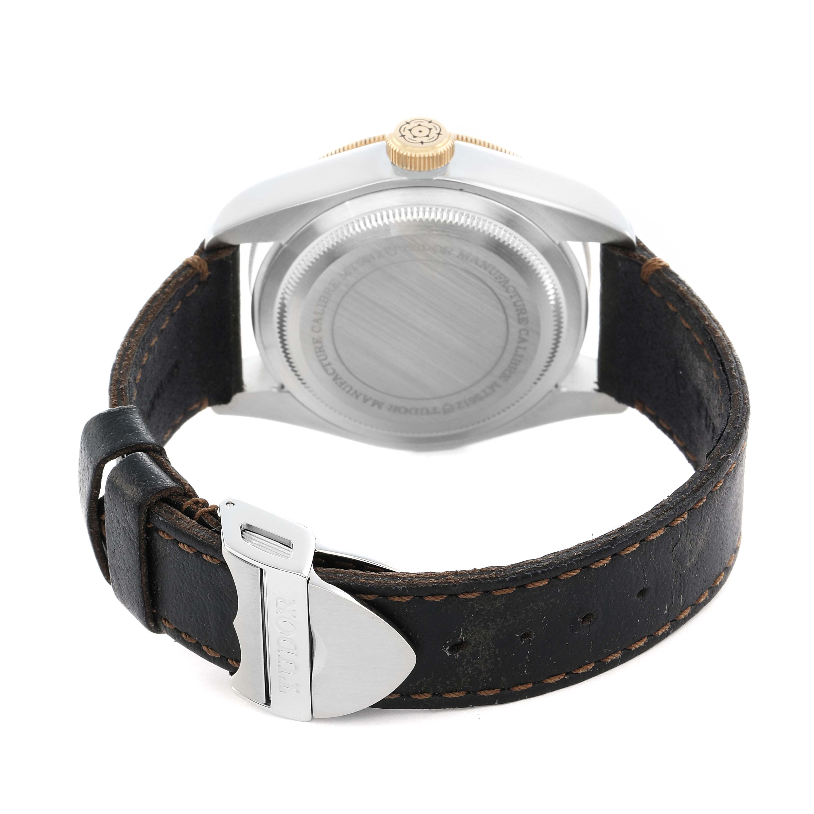 The Tudor Heritage Black Bay 79733 Men
s Steel and Gold (two tone) Black Dial watch is shown from the back, highlighting the case back, leather strap, and clasp.
