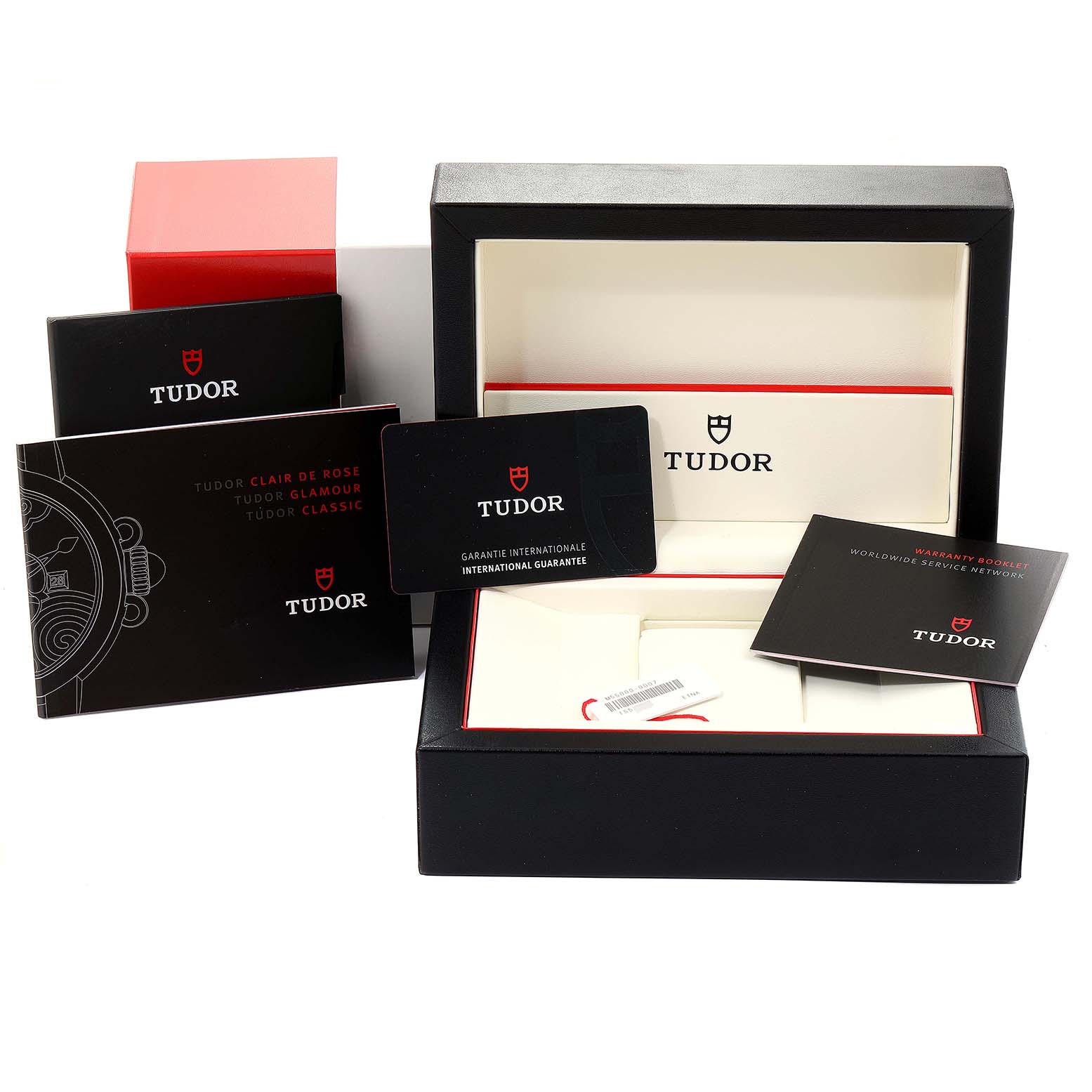 The image shows a Tudor Glamour M55000-0007 Men's Stainless Steel Black Dial M55000-0007 Men's Stainless Steel Black Dial watch box and accessories, including manuals, a warranty card, and packaging from an angled view.
