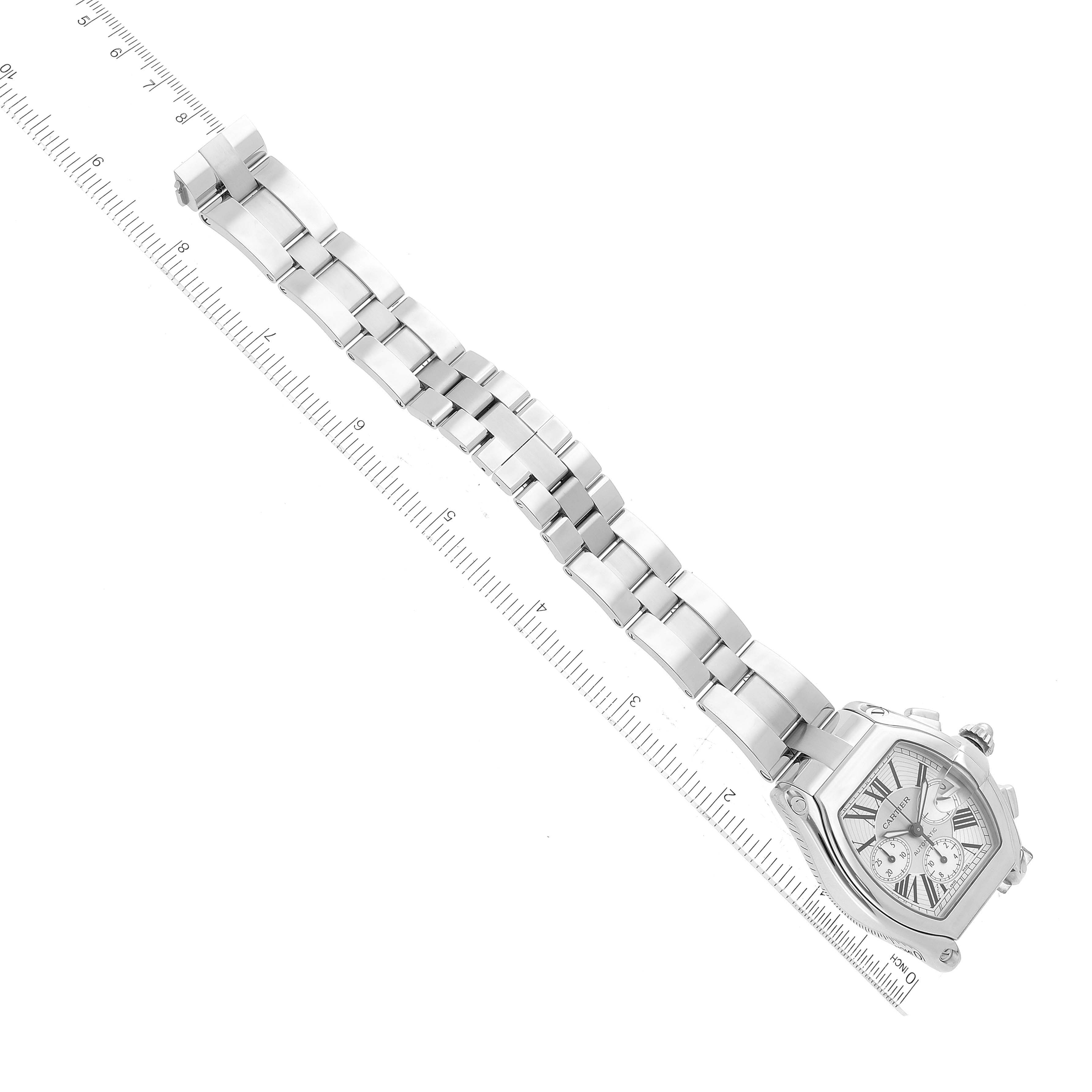 The image shows a top view of the Cartier Roadster W62019X6 Men's Stainless Steel Silver Dial W62019X6 Men's Stainless Steel Silver Dial watch, showcasing the face and the full bracelet laid next to a ruler.