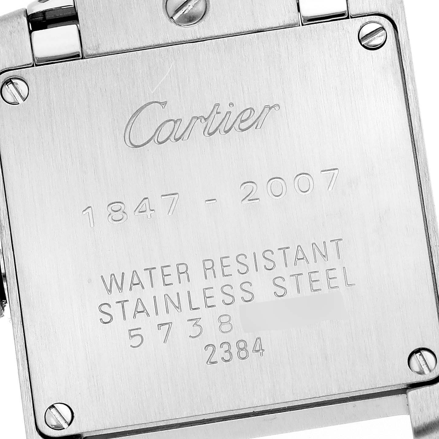 The image shows the back casing of a Cartier Tank Francaise W51035Q3 Women's Stainless Steel Silver Dial W51035Q3 Women's Stainless Steel Silver Dial watch, featuring engraved text and screws.