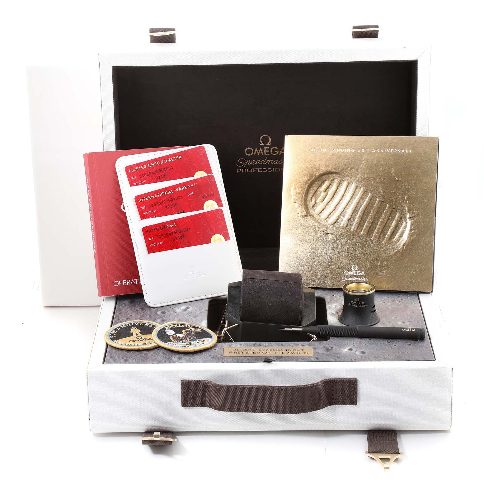 The image shows an Omega Speedmaster 310.20.42.50.01.001 Men's Steel and Gold (two tone) Grey Dial 310.20.42.50.01.001 Men's Steel and Gold (two tone) Grey Dial model watch packaging with accessories including manuals, warranty cards, a pen, coins, and a magnifier.