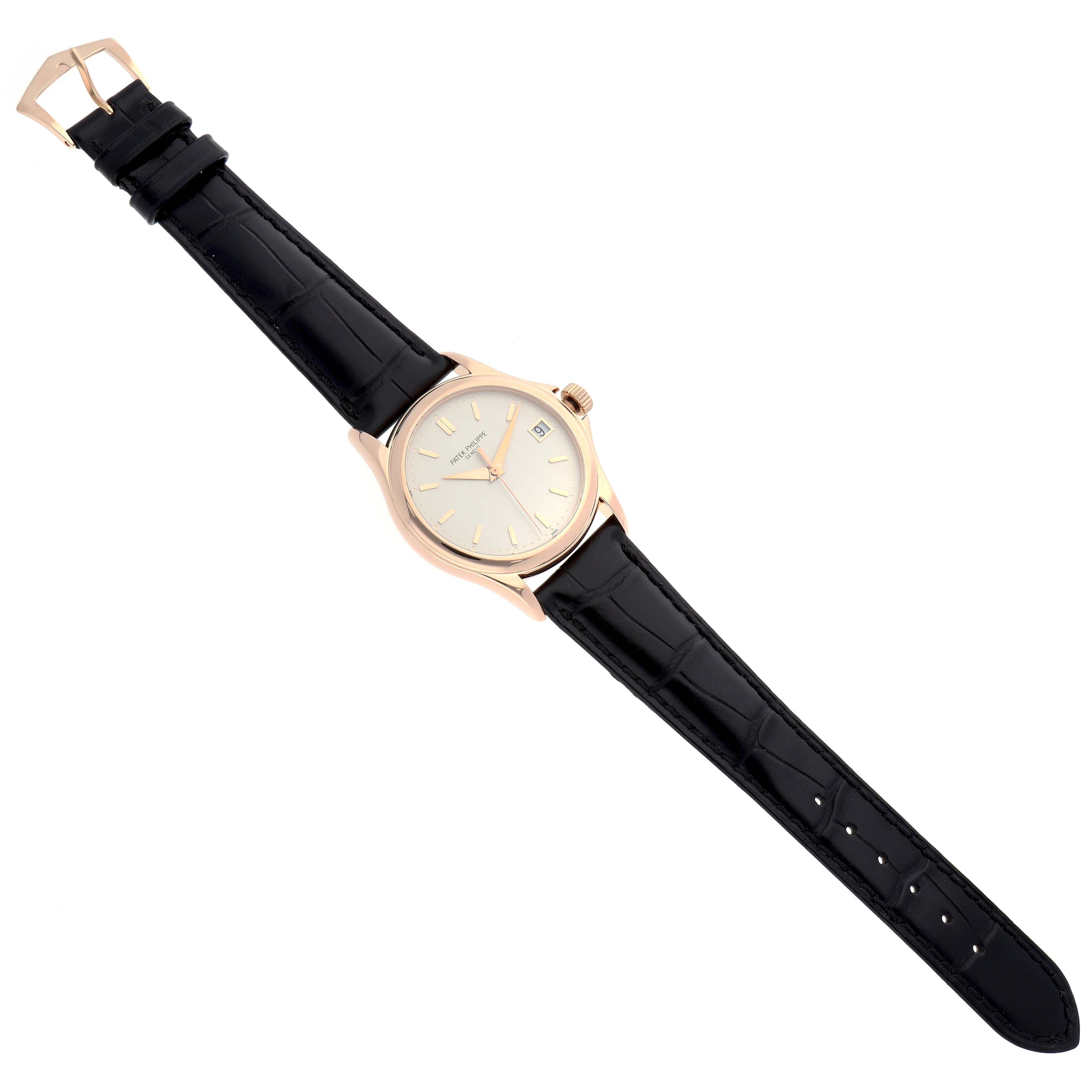 The Patek Philippe Calatrava 5127R Men
s Rose Gold Silver Dial watch is shown from an angled top view, highlighting the dial, leather strap, and clasp.