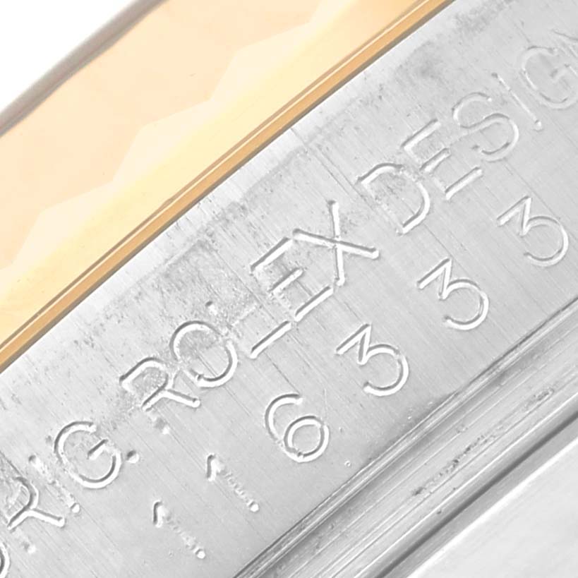 This close-up image shows the engraved serial number and "ROLEX DESIGN" text on the side of the Rolex Datejust 41 116333 Men's Steel and Gold (two tone) Silver Dial 116333 Men's Steel and Gold (two tone) Silver Dial.