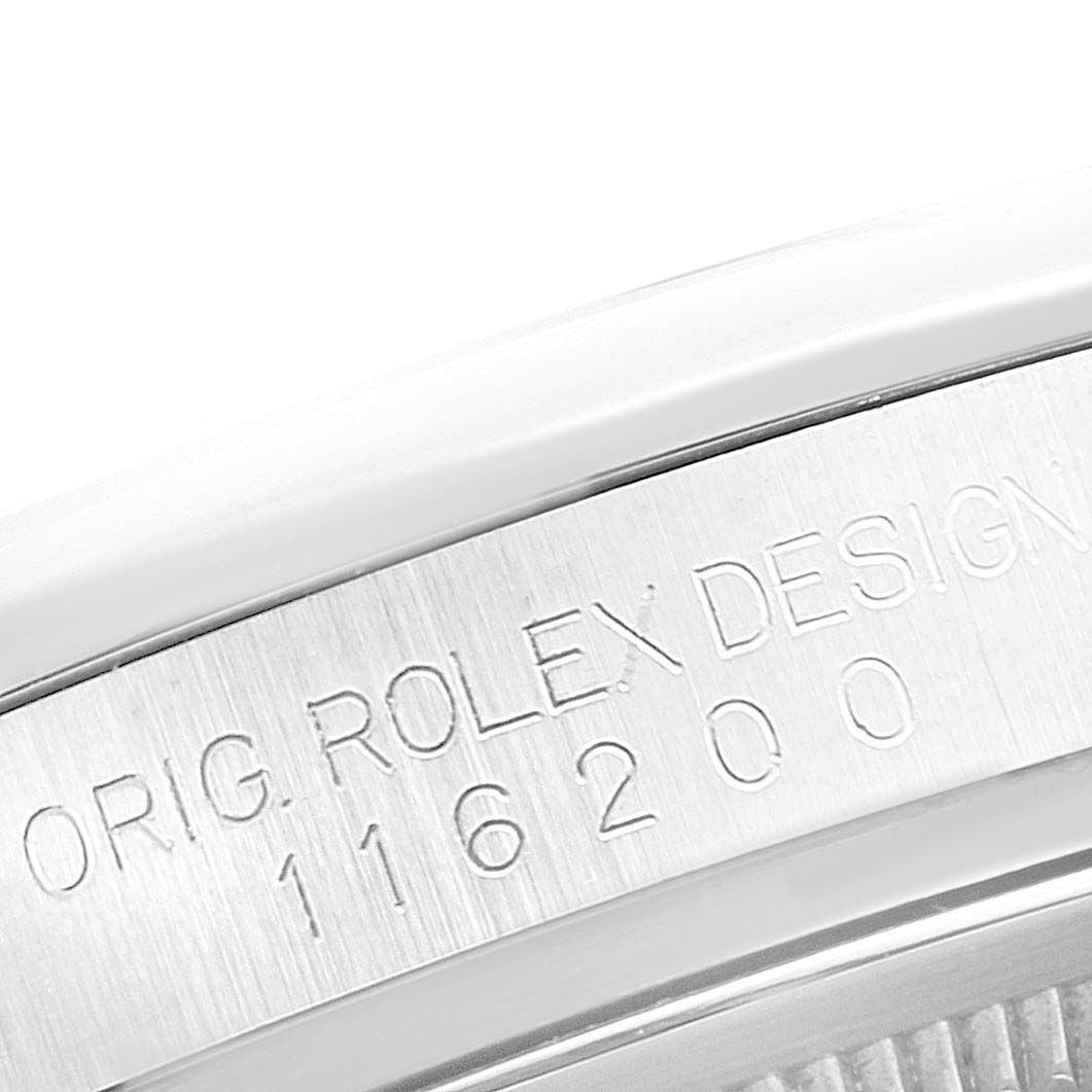 The image shows a close-up of the engravings on the inner bezel of a Rolex Datejust 116200 Men's Stainless Steel Silver Dial 116200 Men's Stainless Steel Silver Dial watch.
