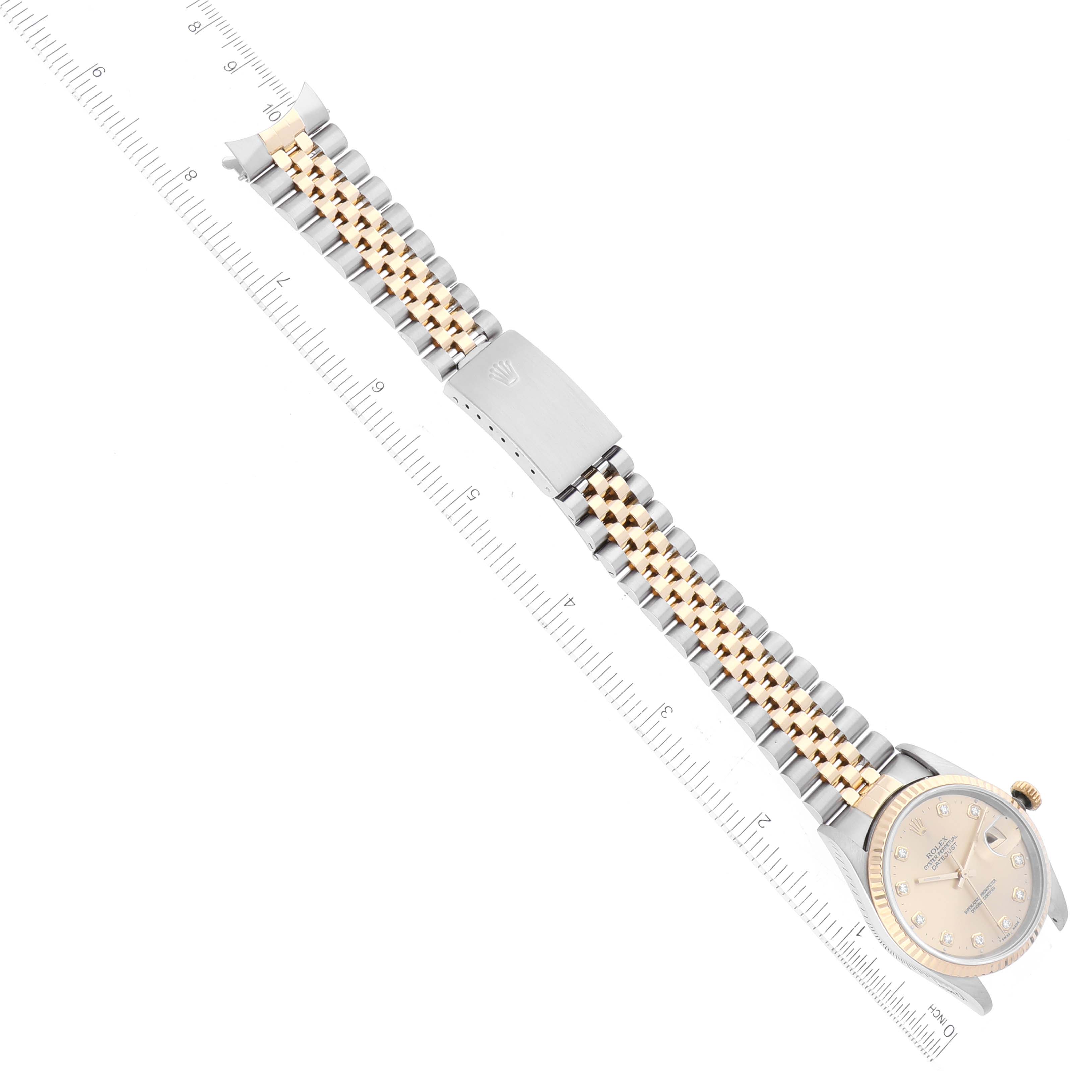 This image shows a top-down view of a Rolex Datejust 16233 Men's Steel and Gold (two tone) Champagne Dial 16233 Men's Steel and Gold (two tone) Champagne Dial watch, emphasizing the dial, bracelet, and clasp with a measuring scale.
