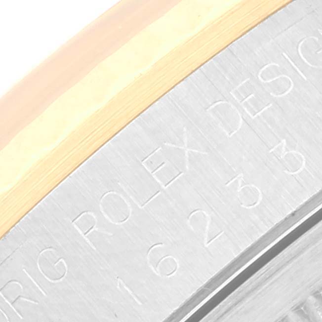 The image shows a close-up of the engraved serial number and "Rolex Design" text on a Rolex Datejust 16233 Men's Steel and Gold (two tone) White Dial 16233 Men's Steel and Gold (two tone) White Dial watch bezel.