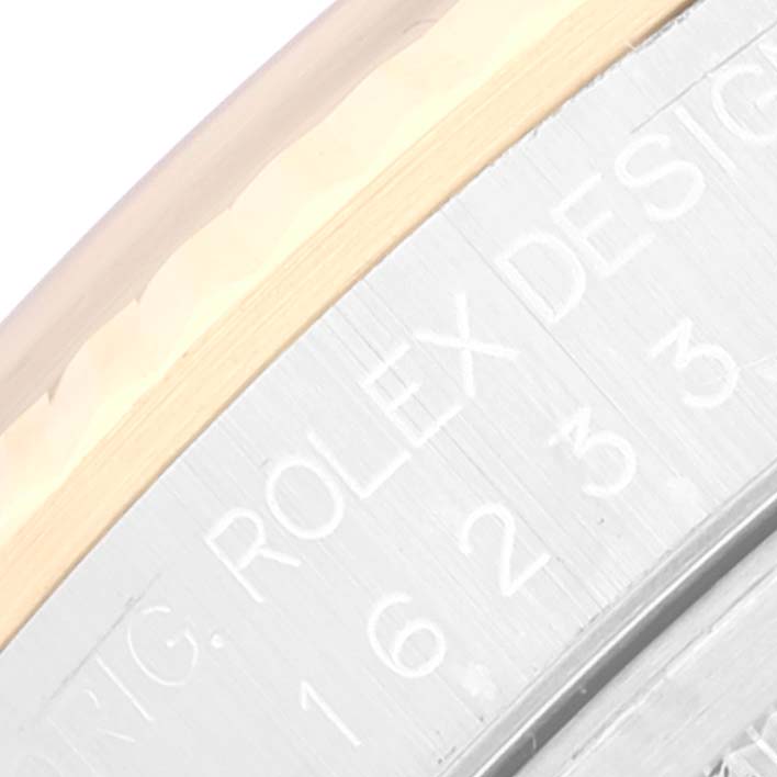 The image shows a close-up of the Rolex Datejust 16233 Men's Steel and Gold (two tone) Mother of Pearl Dial 16233 Men's Steel and Gold (two tone) Mother of Pearl Dial's engraving and the edge of the bezel.